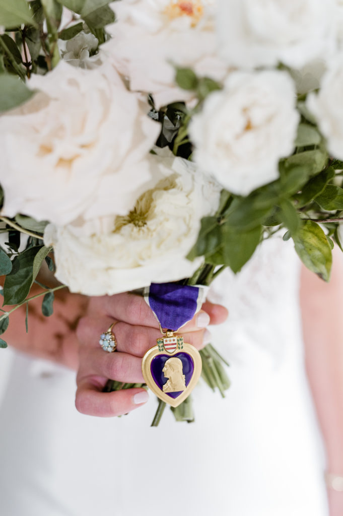 Joanna’s bouquet included the Purple Heart received by her late paternal grandfather, Emory Olin Watson. Filling the need for “something blue,” Joanna wears a very special ring given to her by her mother, Donna Sheheen Watson. Making the ring even more of a family heirloom, it was given to her mother by Joanna’s grandmother, Joan Anderson Sheheen. 