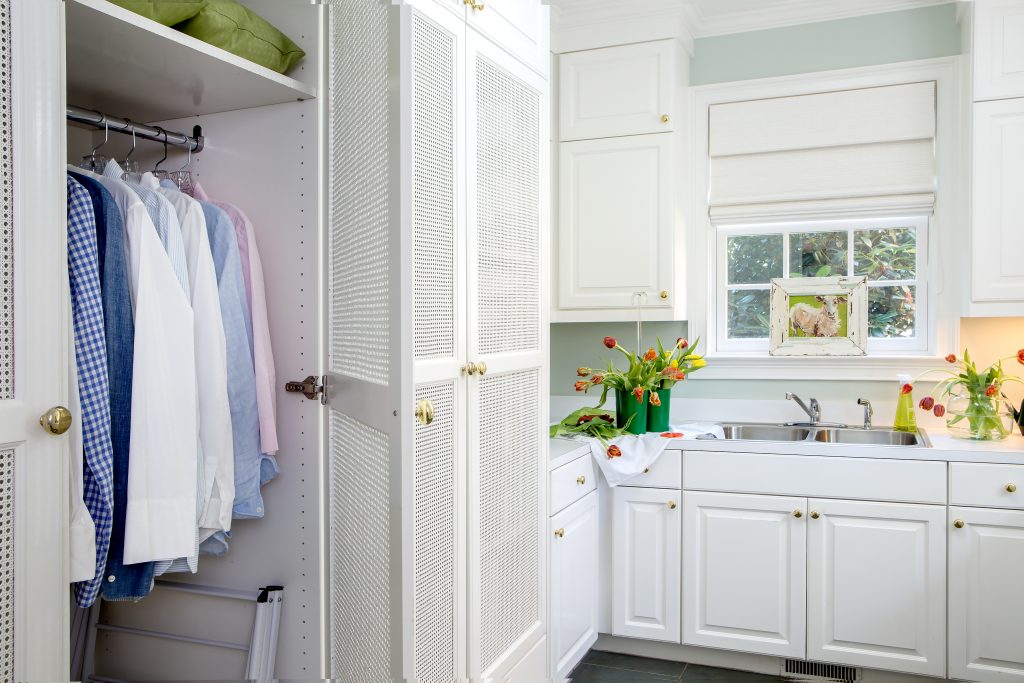 Laundry room doors with cane panels provide air to reach clothes that are drying out of sight. Ample counter space and sink provide a wonderful space for arranging flowers. 