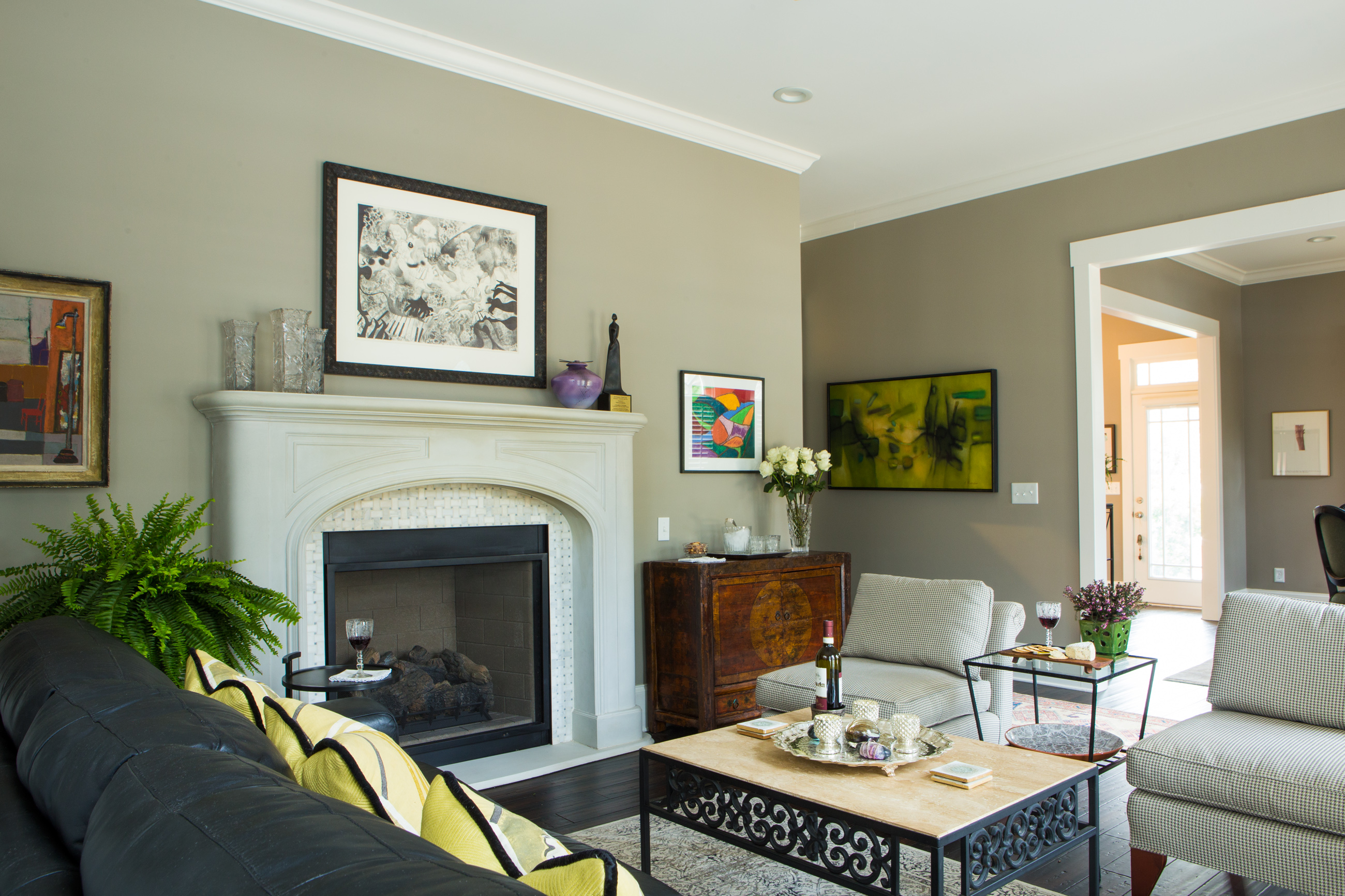 The neutral palette of Shari and Tim’s living room highlights the Carrie McCullum painting to the right of the fireplace. The pair of armless chairs were saved from the destruction of the tree falling into the house in 2016. The basket weave tile surround on the fireplace was handmade in Columbia by David Jones. 