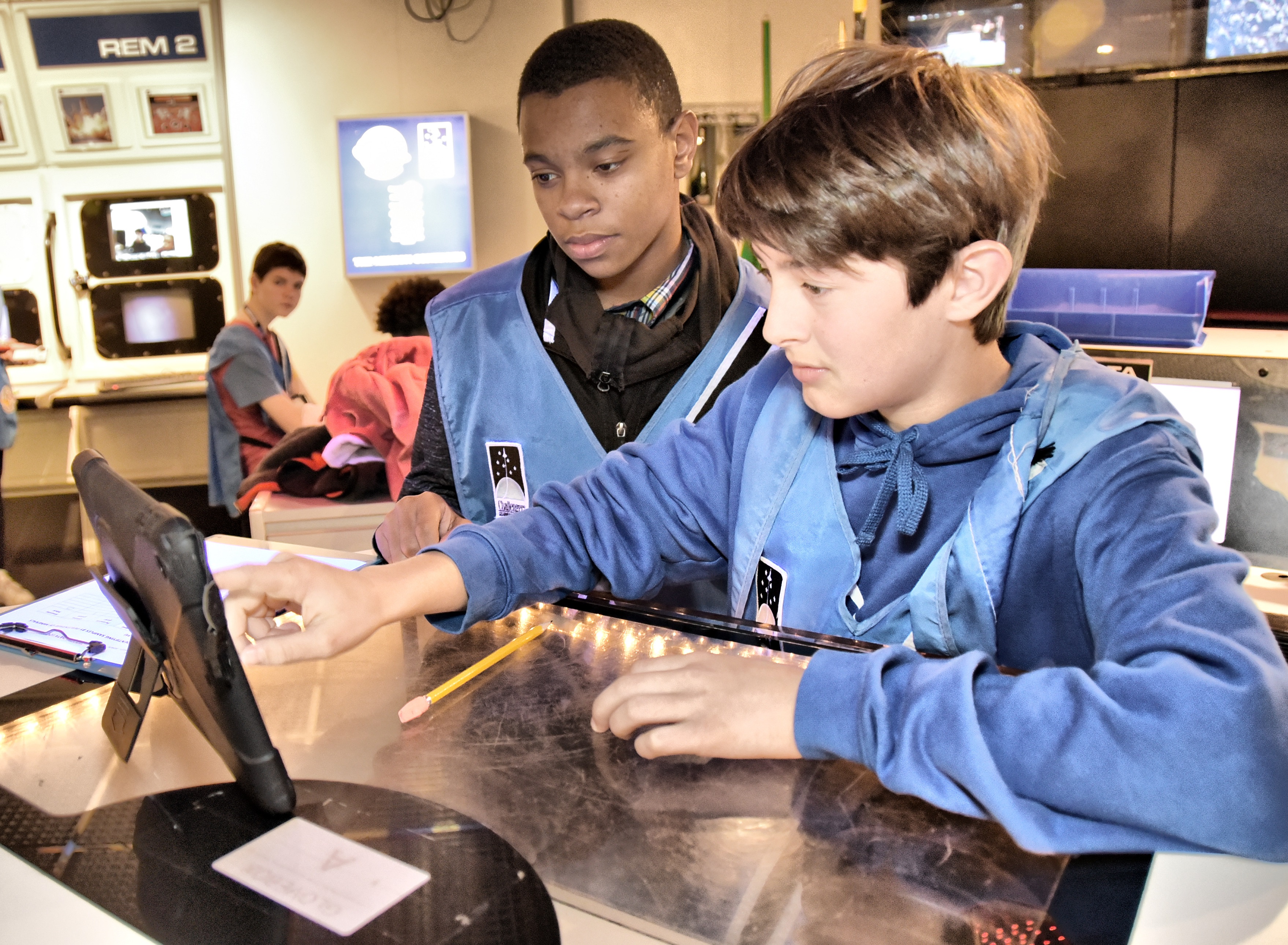 In Space Station, students are astronauts. They conduct experiments, take measurements, and collect data to submit to Mission Control for analysis. Fred Singletary and Micah Elliot, students from Hand Middle School, complete tasks at the glovebox.