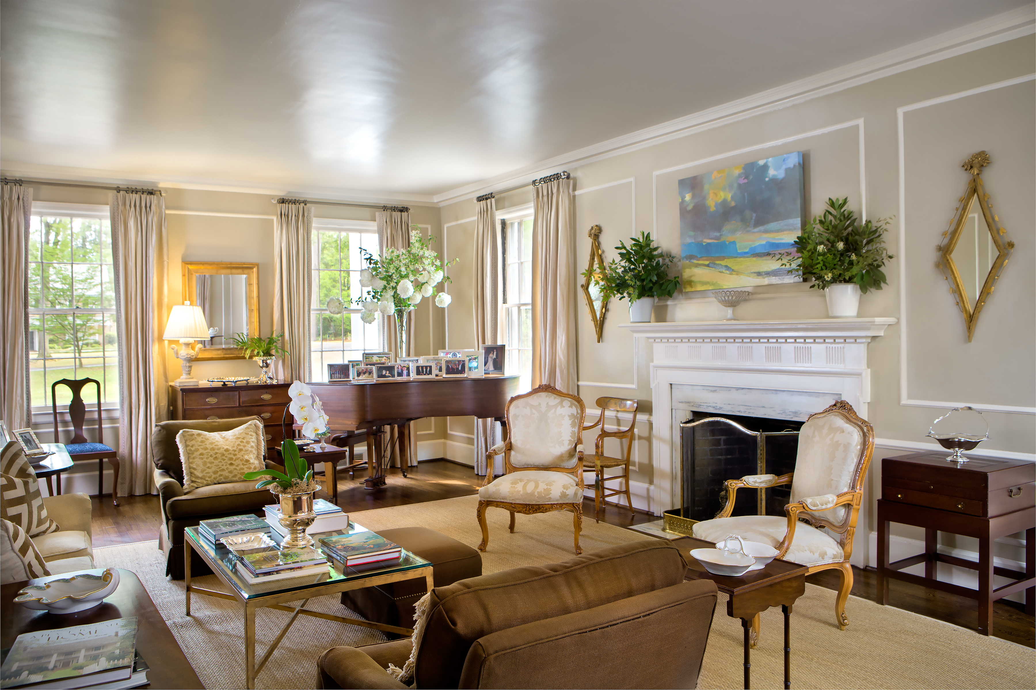 The living room, extending from the front to the back of the home, has wonderful natural light. The moldings are all original, showcasing Lura and Read’s eclectic furnishings, arranged with the help of Gary Hester Interiors from Greenville. The arrangement on the piano includes Chinese snowball viburnum and flowering branches from the garden. 