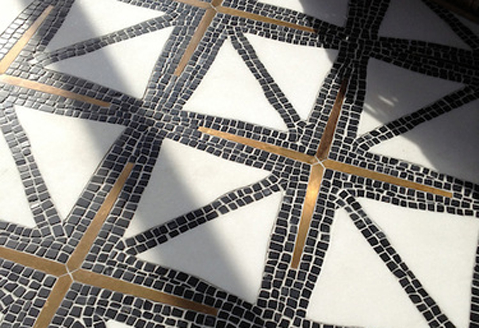 Indus, a stone water jet mosaic, shown in tumbled Nero Marquina, honed Thassos, and Bronze brushed. Designed by James Duncan for New Ravenna Mosaics.