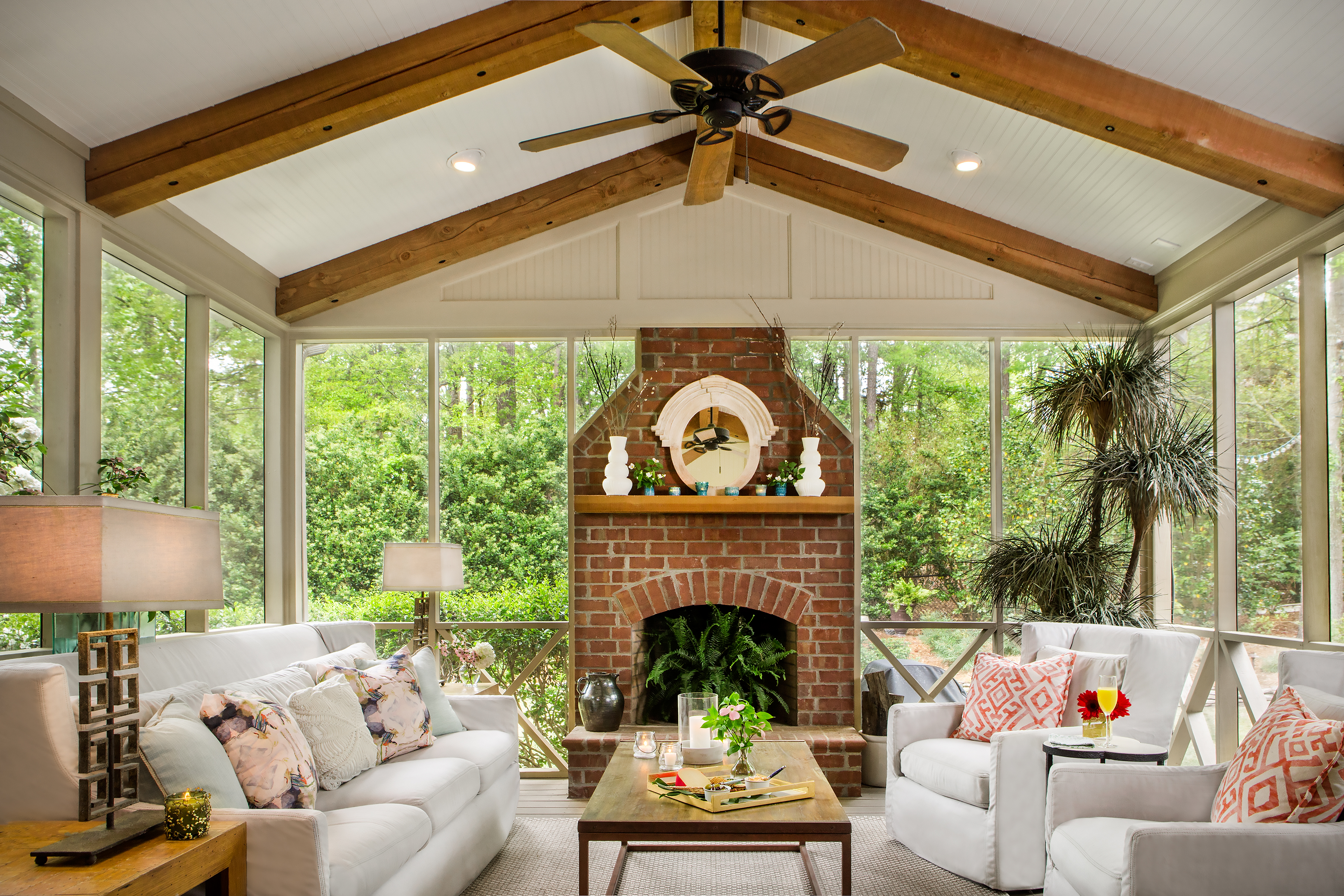 Stuart and Spence use their porch at least nine months out of the year. A mixture of comfortable seating from MACK Home and accents from Southeastern Salvage frame the handsome working fireplace on the gracious screened in porch. 