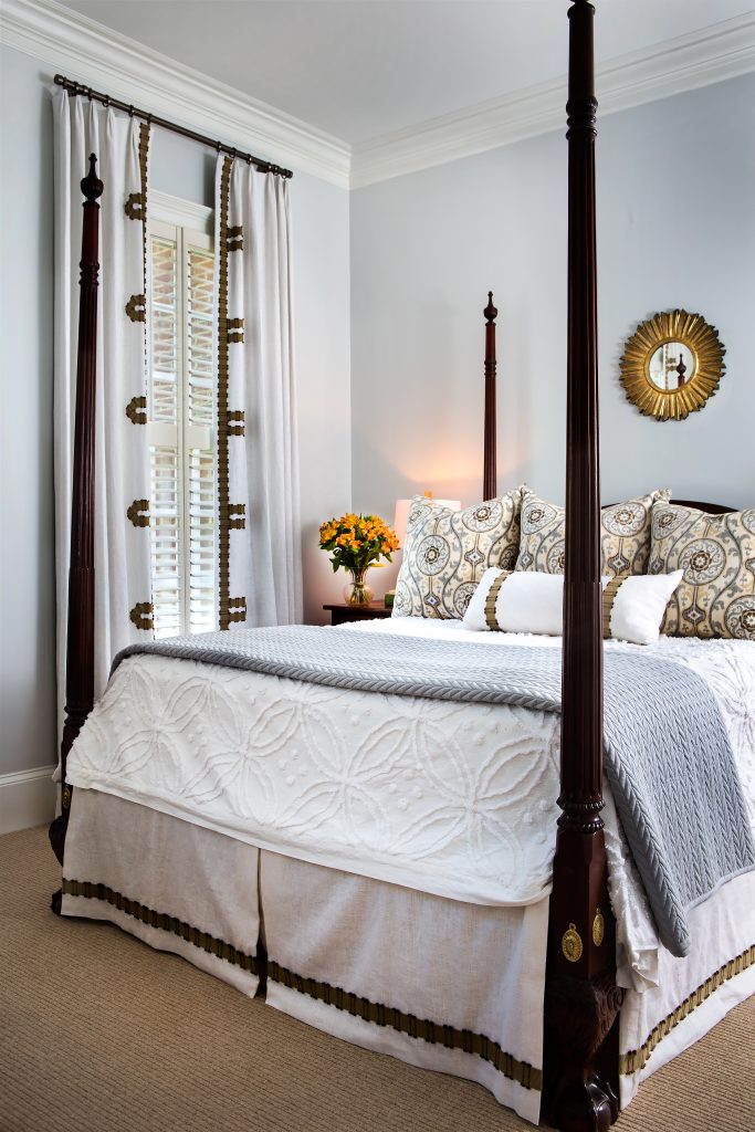 Incorporating the same tape detail on the drapery, bed skirt, and accent pillow helps to pull this space together. Veronica kept the pattern simple on the bedding, resulting in a cohesive look that doesn’t compete with the unique ornamentation on the panels.