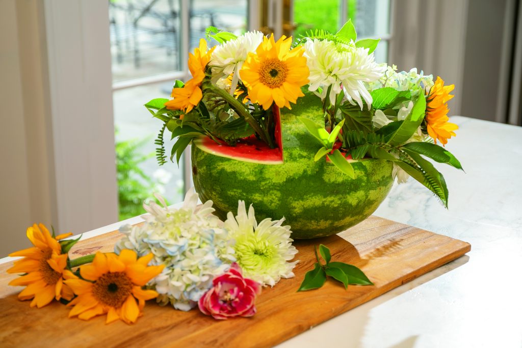 Arrange fresh flowers and greenery in your watermelon basket, pressing the stems into the flesh to help keep your blooms upright and beautiful. Display prominently and get ready for compliments!