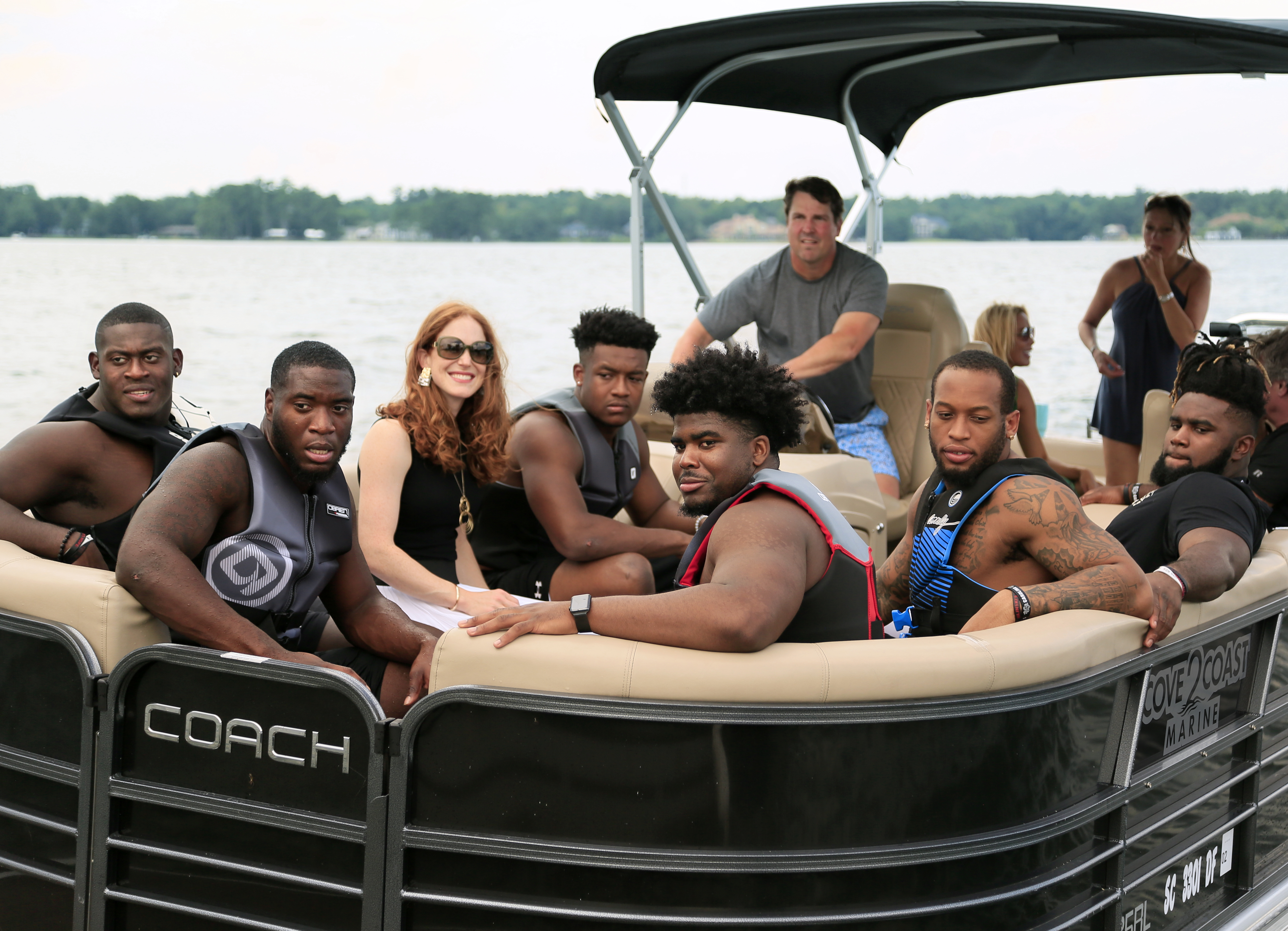 Margaret Clay enjoys a boat ride with Gamecocks (left to right) Kobe Smith, T.J. Brunson, D.J. Wonnum, Keir Thomas, Eldridge Thompson, and Sadarius Hutcherson with Coach Muschamp at the helm.
