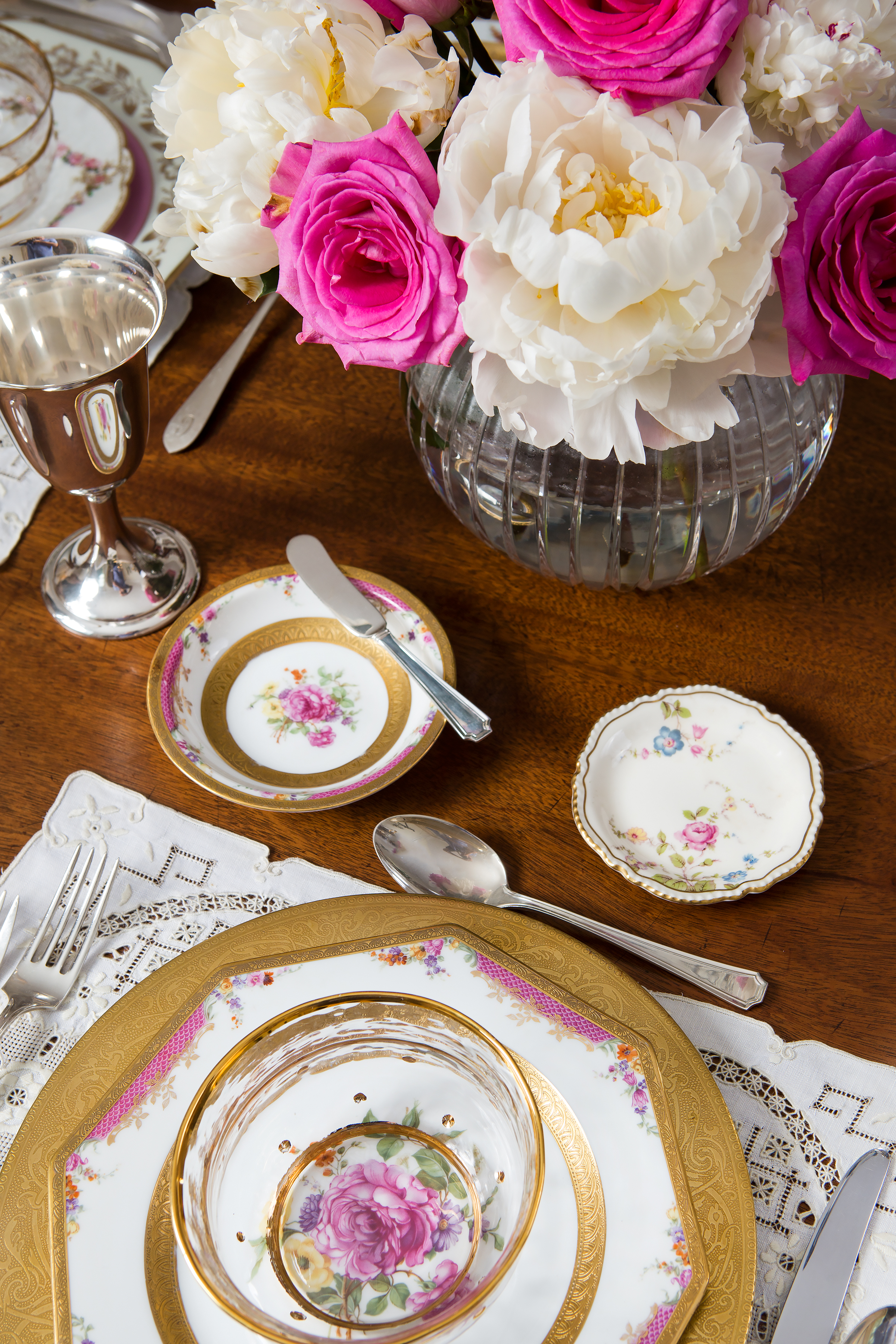Mix and match antique floral Haviland patterns throughout your table for a collector’s dream. Pale lavender and pinks with gold accents are set off by cream peonies and lush rose blooms. Modern crystal vase and bowl create as well as complement the affair. The perfect grouping for a ladies’ lunch or bridal shower. 