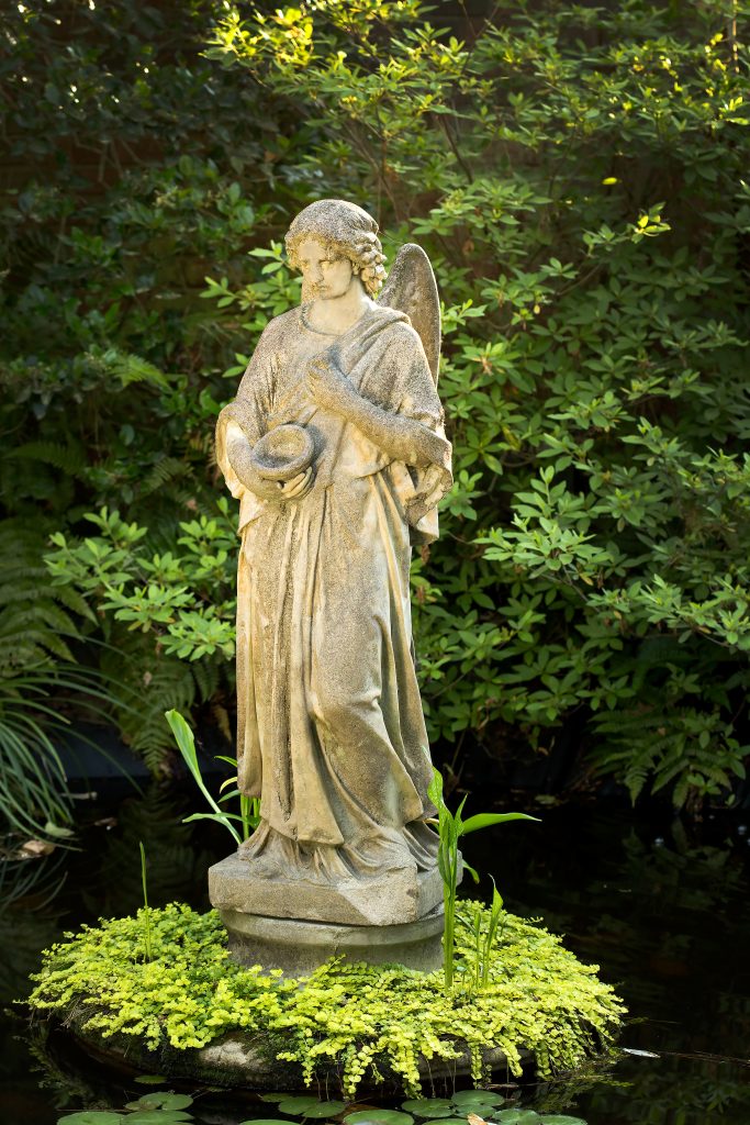 When the Naars purchased the property in 1991, nearly 30 years ago, some of the statues were already in the yard. An existing lily pond near the entrance is planted with hosta, cast iron plant, ferns, azalea, and wisteria. Near the house, the driveway winds around a hedge of pittosporum encircling an elegant, bronze mermaid with a sea turtle and some fish. 