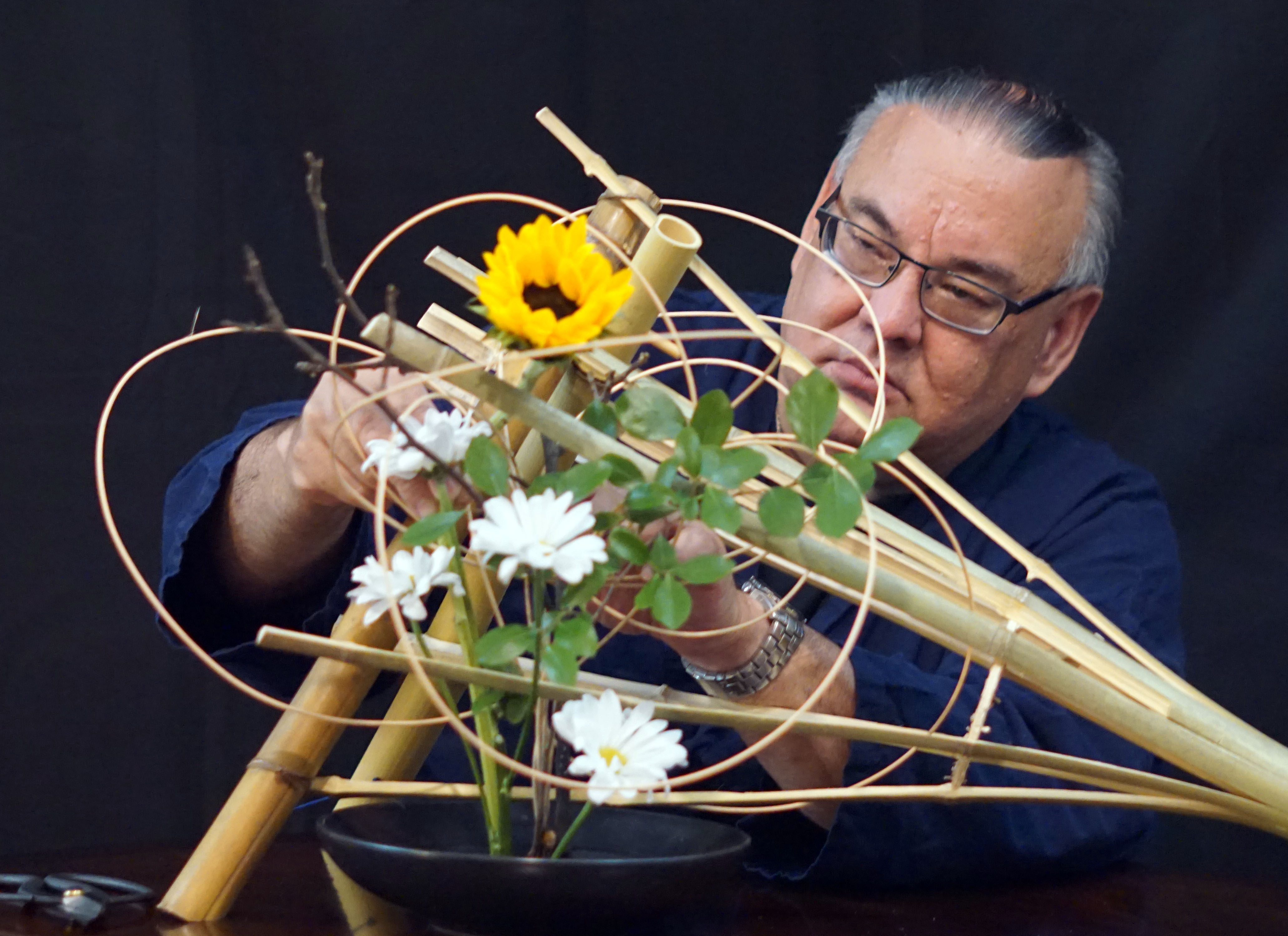 John Spence learned ikebana arranging from his mother, Kikue, whose name means chrysanthemum in Japanese. Ikebana may be accomplished by taking a familiar plant or flower and presenting it in a new way. Unnecessary elements are eliminated, possibly a petal, leaf, or stem.