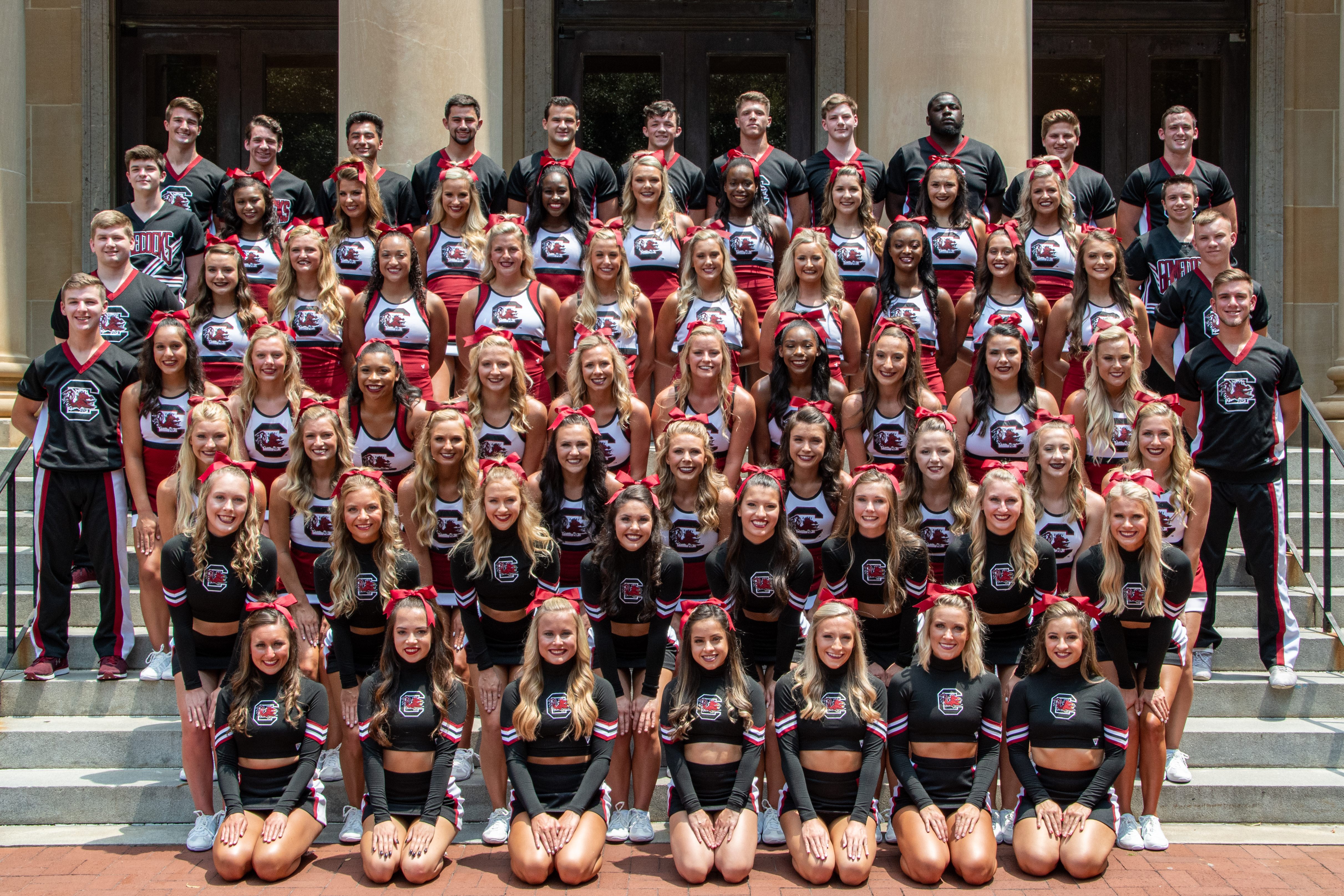 The 2019-2020 USC Cheerleaders, All-Girl Squad in the garnet uniforms and the Coed Squad in the black uniforms. 