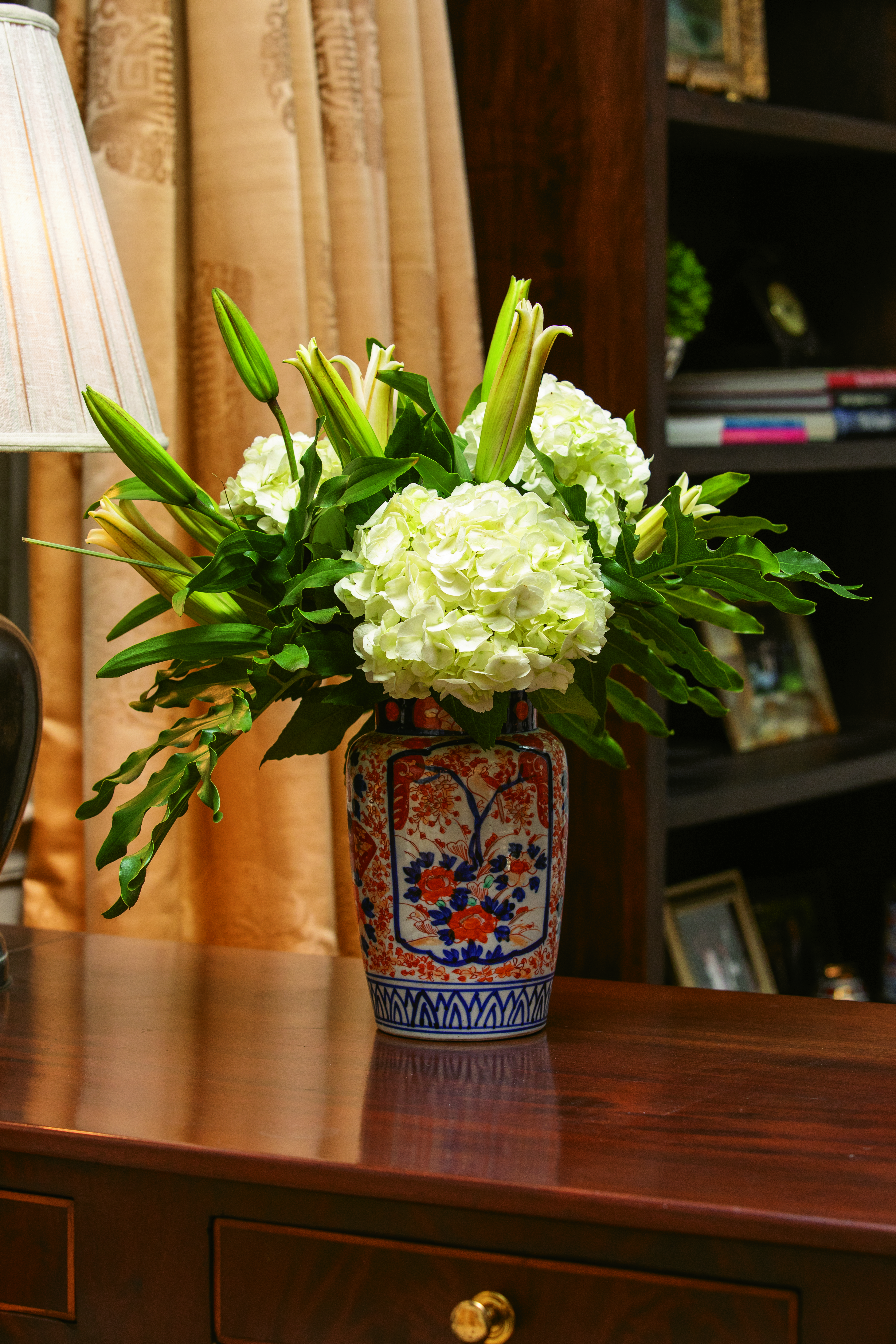 An Imari jar conceals the stems of this arrangement of three white hydrangea blooms and philodendron ready to complement glorious lilies as they open. Remember to add water frequently. 