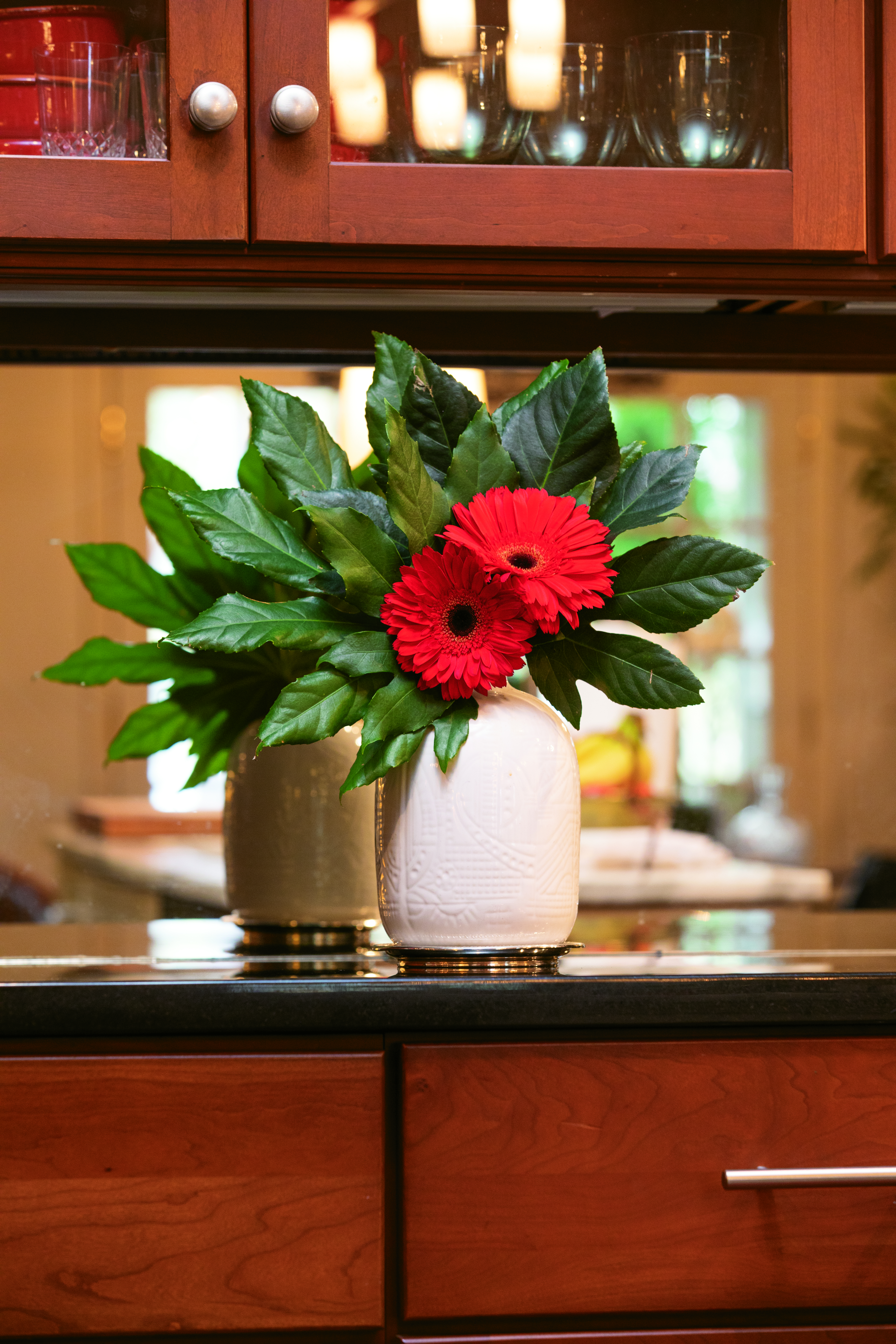 A simple arrangement of gerbera daisies showcased against Fatsia japonica leaves cut from the yard is strikingly bold and simple. Flowers courtesy of Trader Joes.