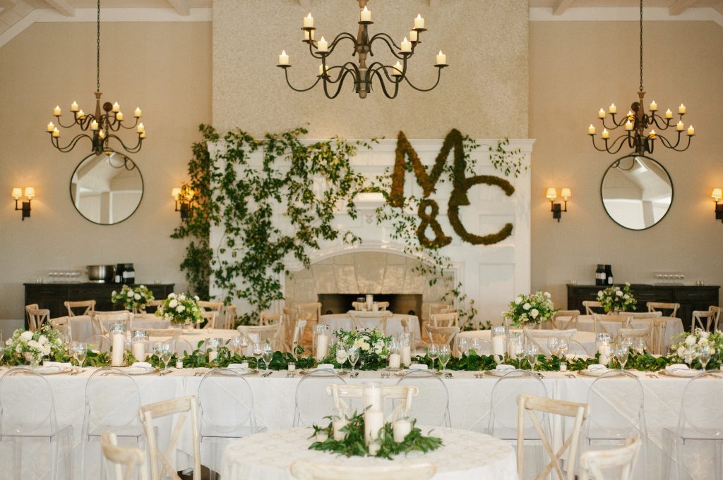 Branch Design Studio transformed The River Course with white roses, hydrangeas, baby’s breath, and greenery. The MC monogram hanging from the mantel was covered in green moss and smilax curled and sprawled throughout the room to create romantic Southern elegance.