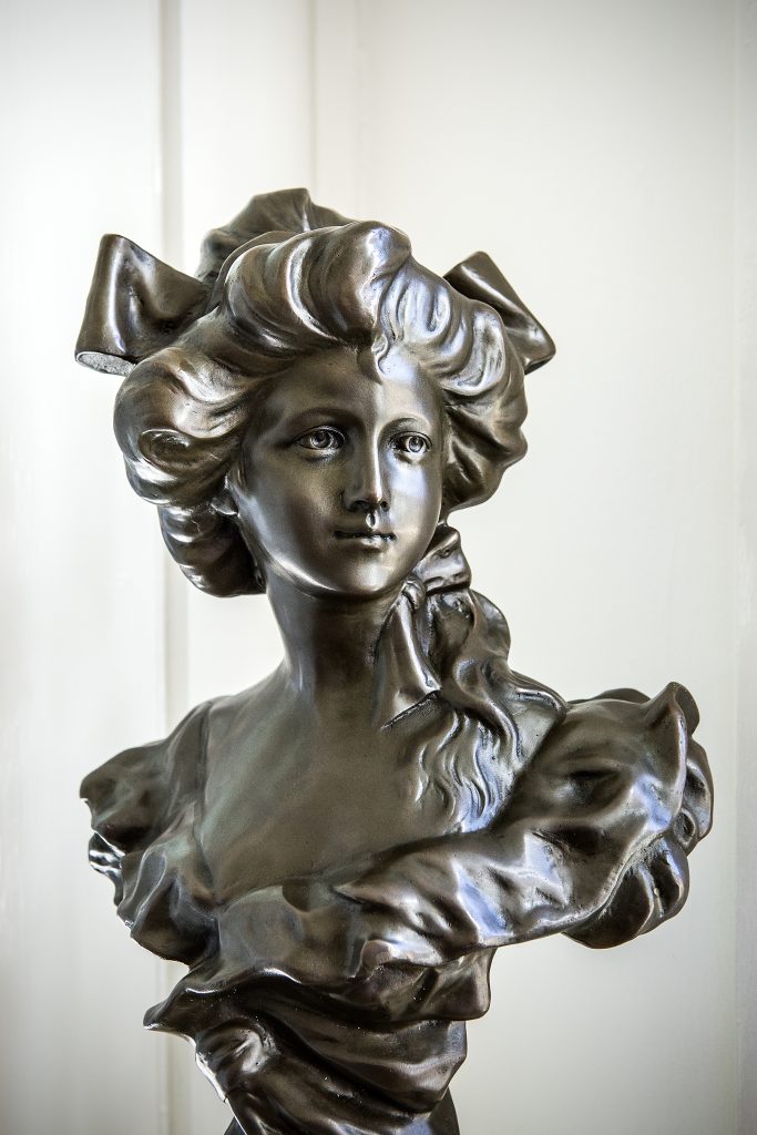 The bust that rests on a pedestal in the dining room was bought at auction as a gift to Jenni from Andy.