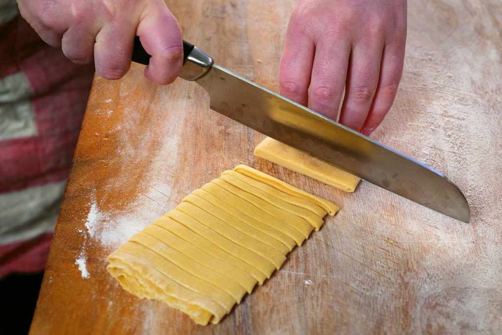With a sharp knife, cut the noodles into strips. 