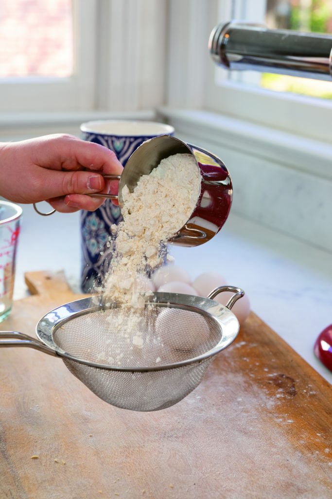 Use a sieve to shake the lumps from the flour before making a mound on the dough board. 