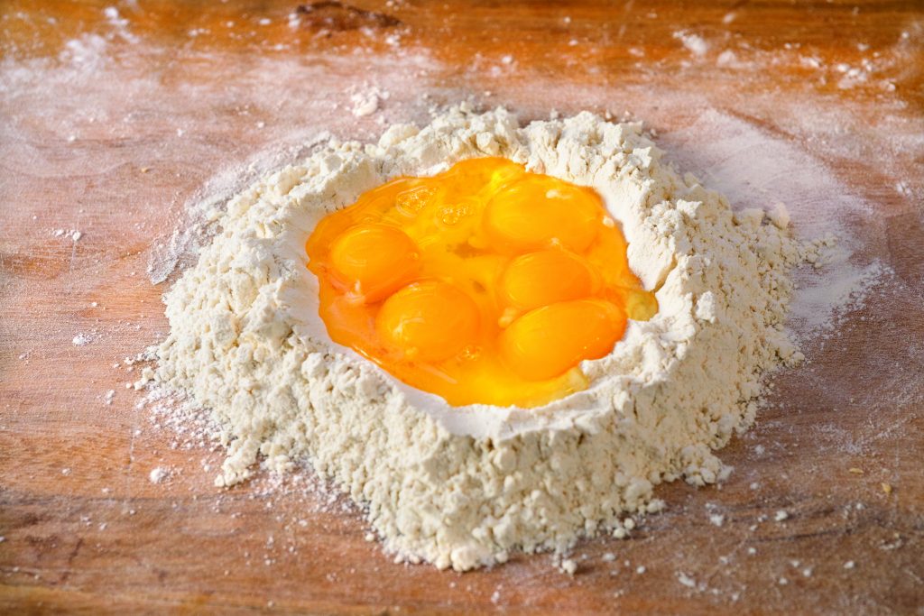 Create a well in the middle of the flour mound large enough to fit the eggs.