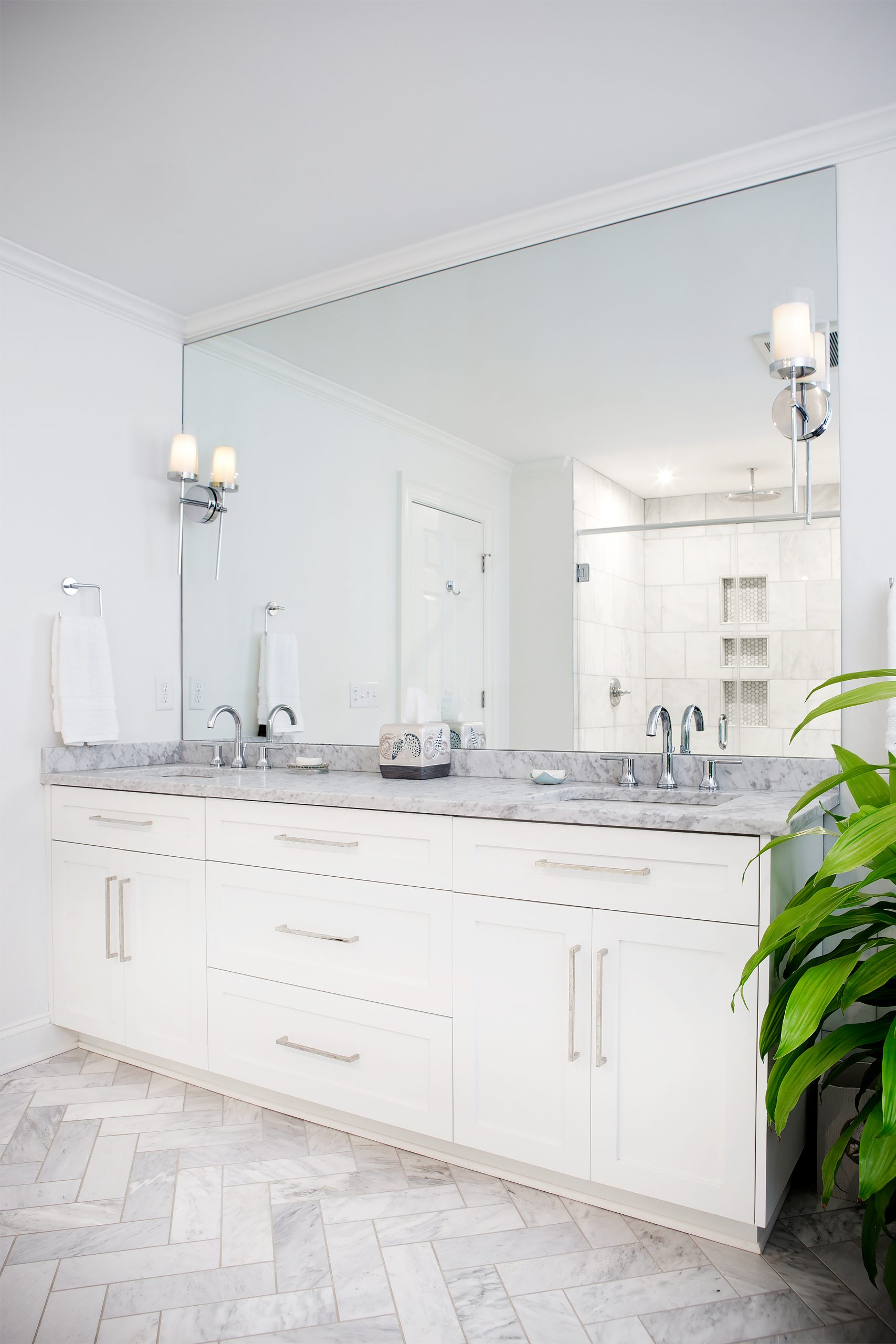 Lucas Bunch turned the former master bedroom into a master bathroom. The beautiful herringbone-patterned floor, two-sink vanity, and walls are all Carrara marble. 