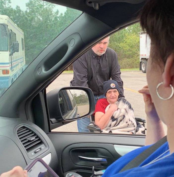 Dori Tempio with Able South Carolina practices social distancing from her car while delivering food and supplies to a woman and her brother.