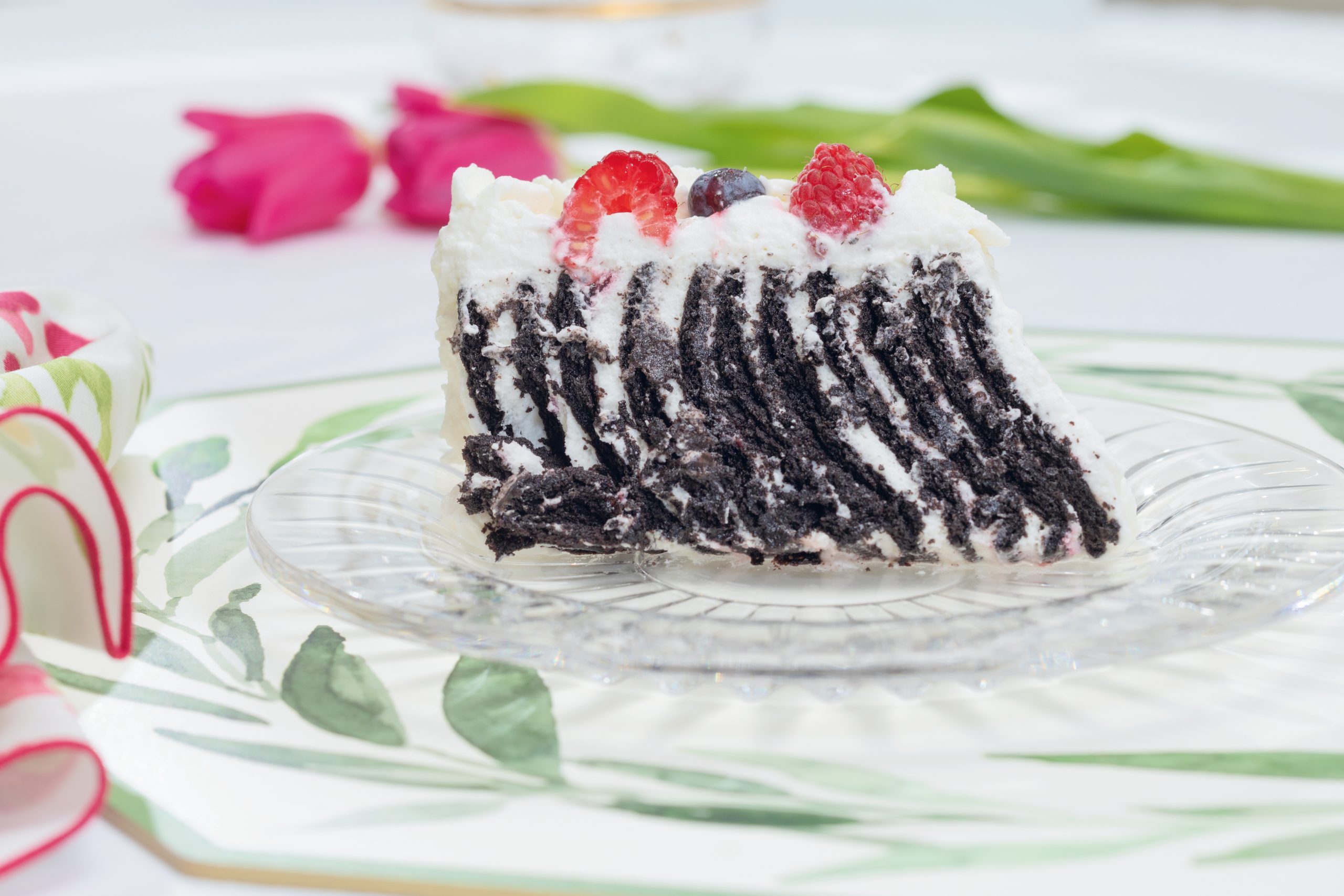 A slice of the Chocolate Raspberry Icebox Cake reveals zebra-like stripes of chocolate and cream. Courtesy of non(e)such: floral Ballard napkins.