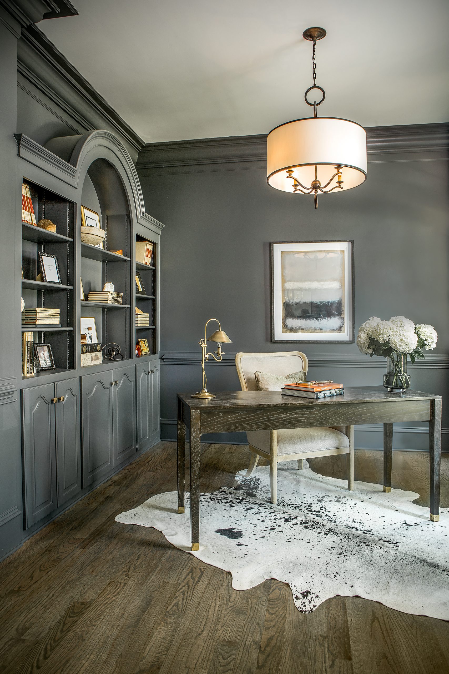 Veronica chose Sherwin-Williams’ Peppercorn gray for the office walls and dining room ceiling in the front of the house. The bold contrast with layers of white and dark create a perfect artistic balance. A hide rug from Southeastern Salvage grounds the office and draws attention to the brass feet of the desk. 