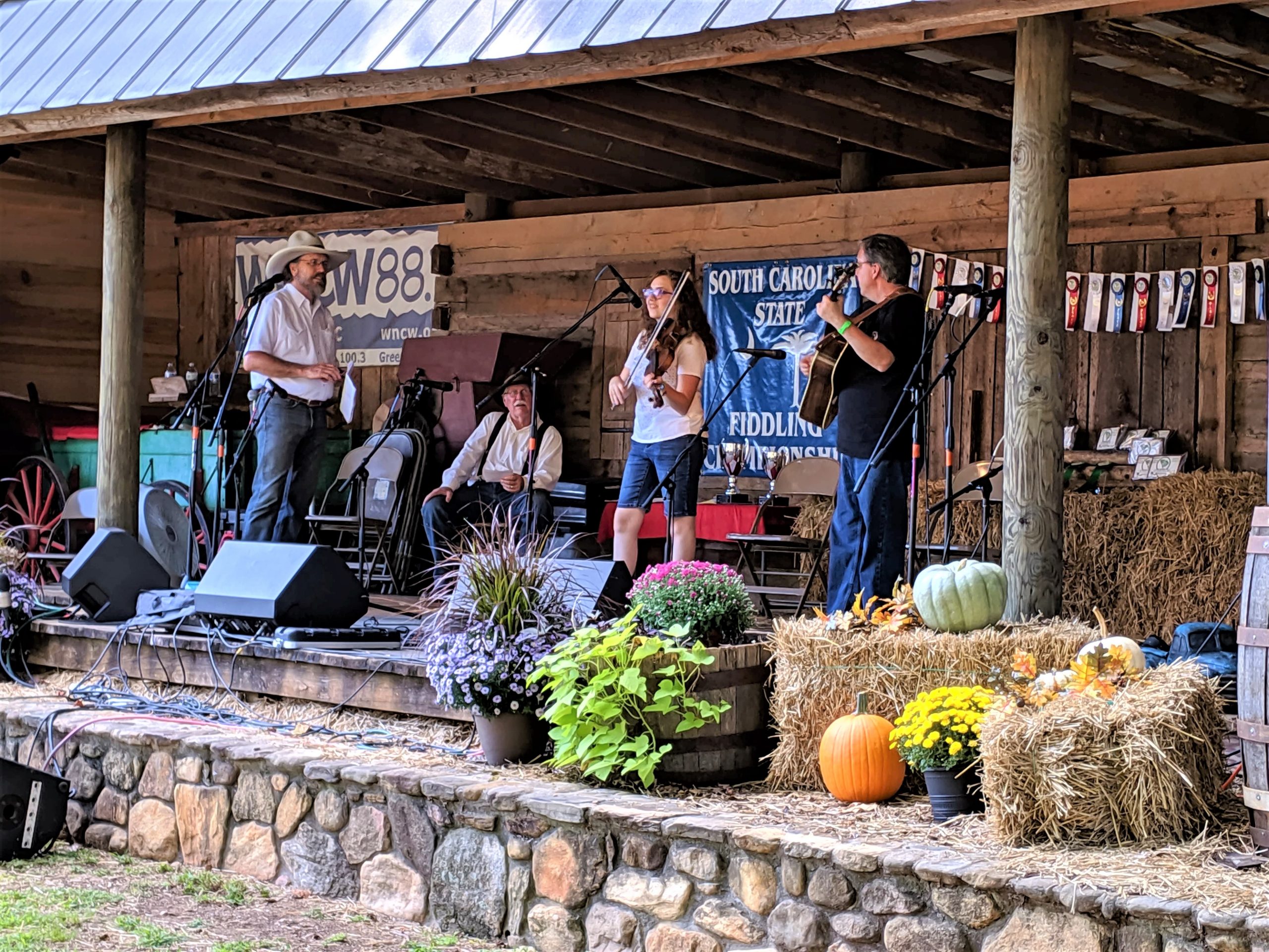 Ella Thomas competes in the junior fiddle division at the 24th Annual Hagood Mill’s Ole Time Fiddlers Convention, where she won first place in the S.C. State Fiddling Championship in September 2019. Greg “Buffalo” Barfield and Dan Wood stand to Ella’s right, and her father, Frank Thomas, plays guitar and almost always accompanies her. 