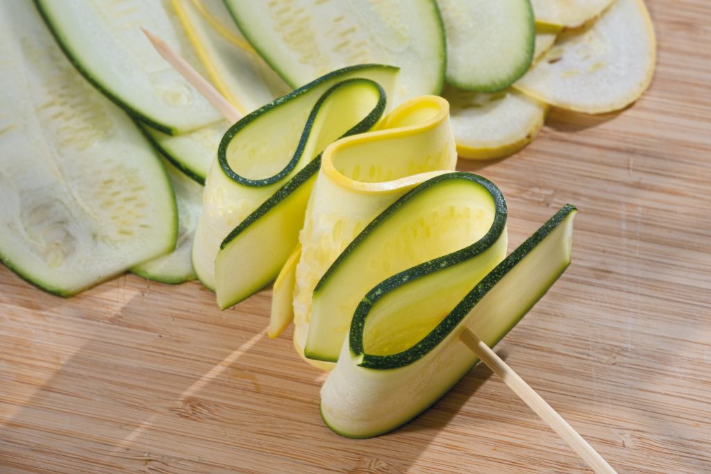 Use a vegetable or potato peeler to slice the squash or zucchini into thin, wide ribbons. 