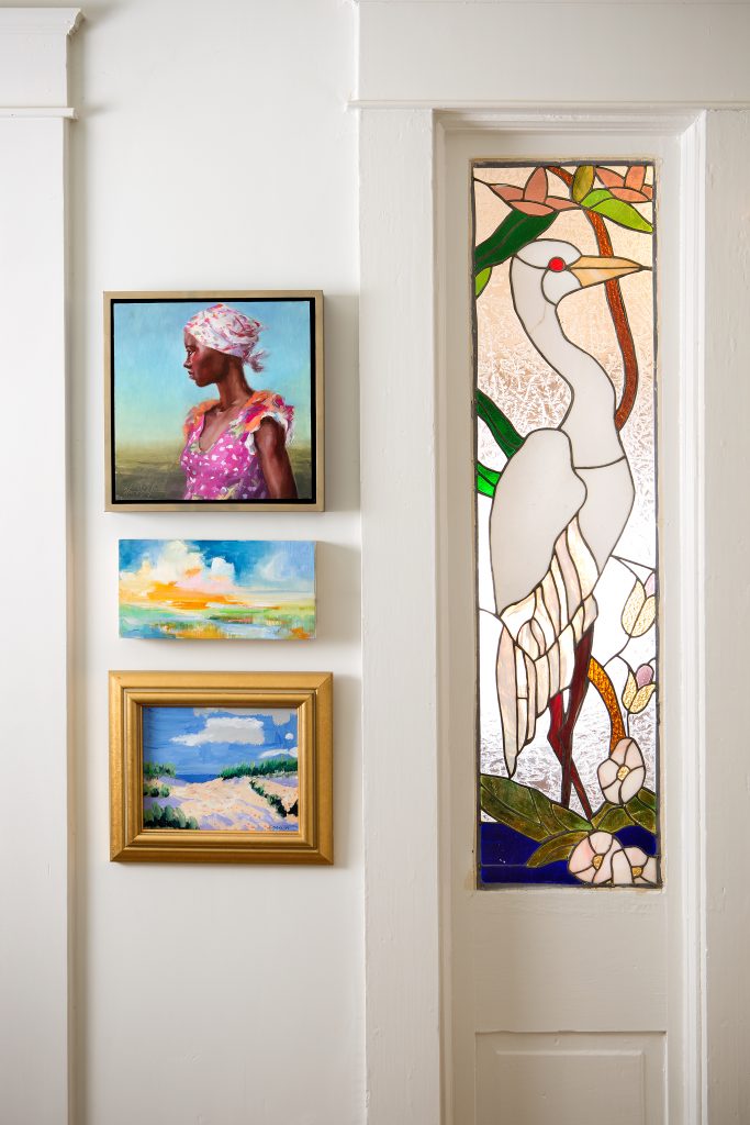 The previous home owner was an artist who created stained glass windows to frame the front door and hallway to the kitchen. The addition of AnnaBelle’s growing collection of paintings sparks conversation and brings joy. 
