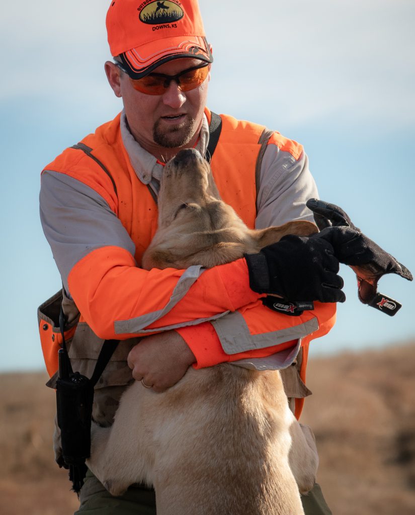  Erik Vrbas enjoying a break between fields with one of his Labrador retrievers, Spyder.