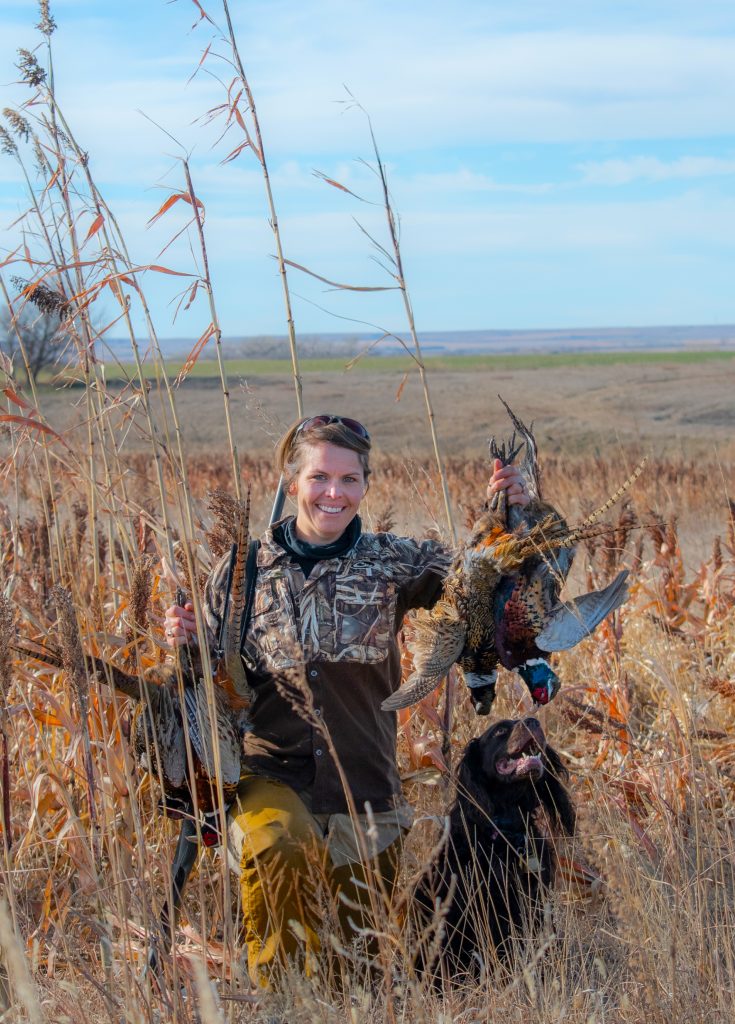 Sarah Nell Blackwell with her Boykin spaniel, Samson, showing a day’s limit on the Kansas prairie.