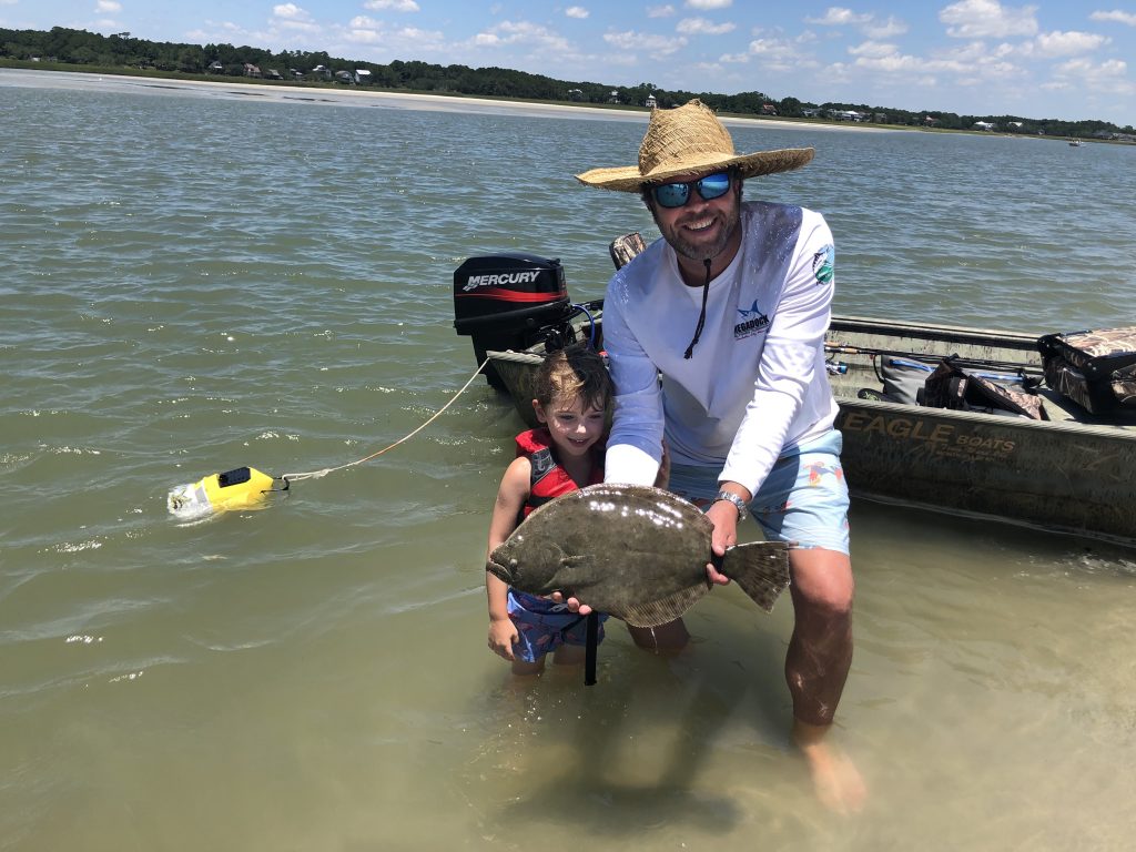 Matt Mungo proudly helps his son, Stewart, show off his first flounder catch!
