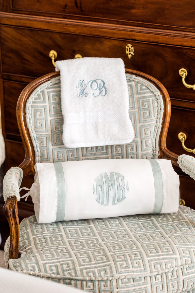 A bolster with an appliqued monogram is the perfect bed accessory, and a 100 percent cotton hand towel with stitched monogram initials in Magnificence will make any guest feel welcome. 