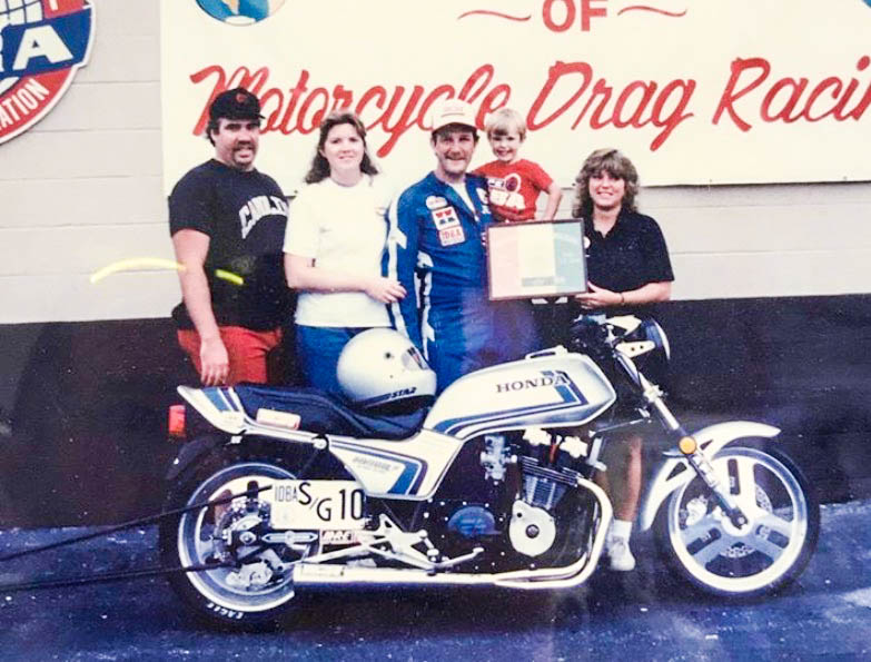 Jeff holds his son Jeffry, Jr. after he won the 1988 World Series of Motorcycle Drag Racing. At his right is Nora.