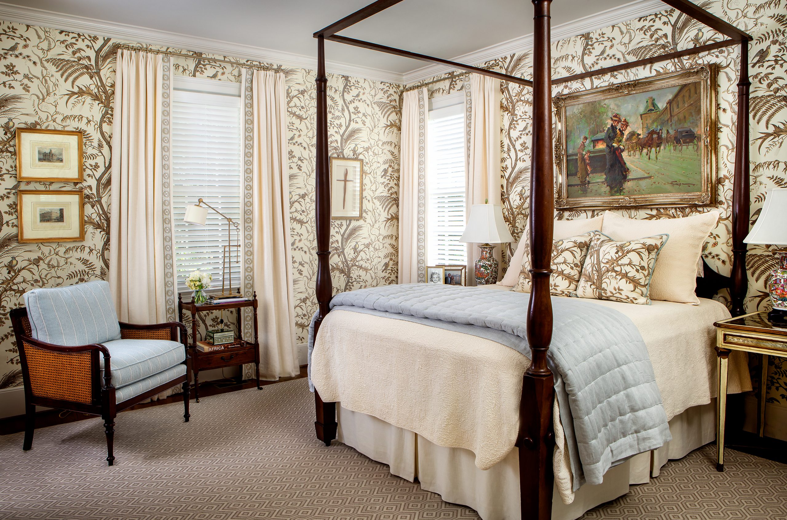 The guest bedroom is beautifully wrapped in Brunschwig & Fils Winterthur documentary wallcovering Bird & Thistle. Accenting the paper, an inviting mahogany canopy bed is dressed in a cream matelassé coverlet with pale blue tufted blanket and throw pillows.