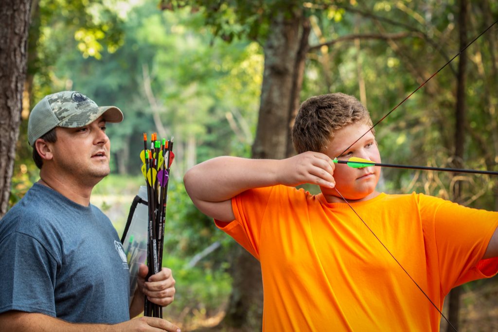 Daniel Beckham, Truth in Nature’s regional director of the Carolinas, is a Camden resident, avid outdoorsman, and father of three. Daniel assists Hunter with archery practice.