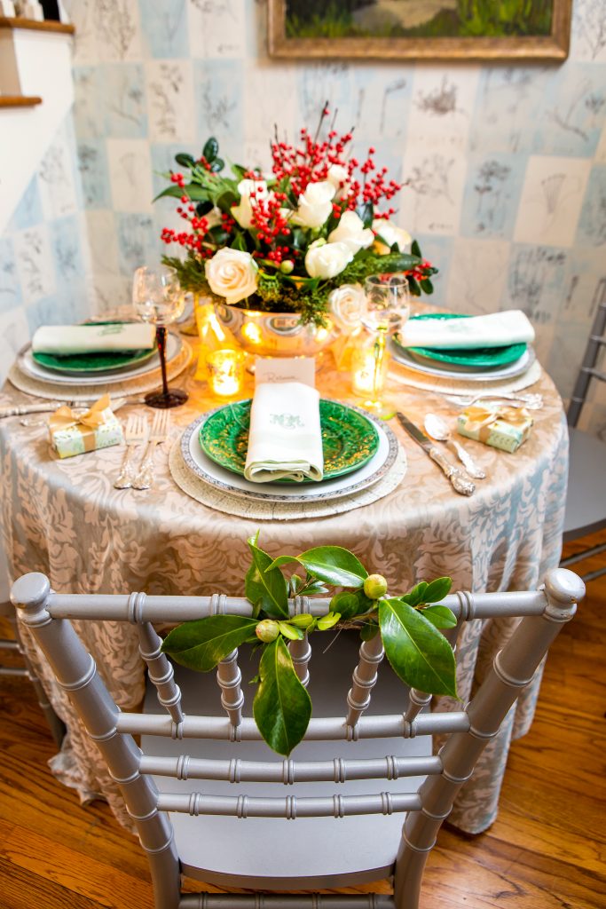 The Mabrys’ table in the entrance hall is encircled by wooden chairs decorated with a perfect camellia bud that Catherine wires to the back. Purchased specifically for this purpose, the bamboo-patterned gray chairs spend the rest of their life in the attic. 