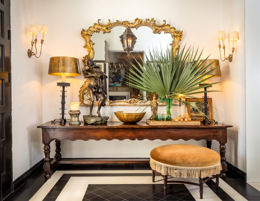 A lovely 17th-century French table is the focal point of the foyer, with black marble and limestone floors. The mirror is a French antique, purchased in New Orleans 28 years ago, and the lantern seen in the reflection of the mirror is Italian.