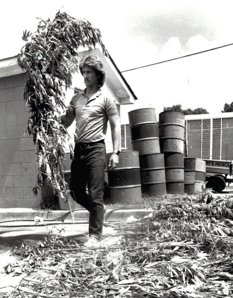  Narcotics officer Leon Lott with seized marijuana plants at the old Richland County Sheriff’s Department headquarters on Huger Street, mid-to-late 1970s. Photo courtesy of RCSD