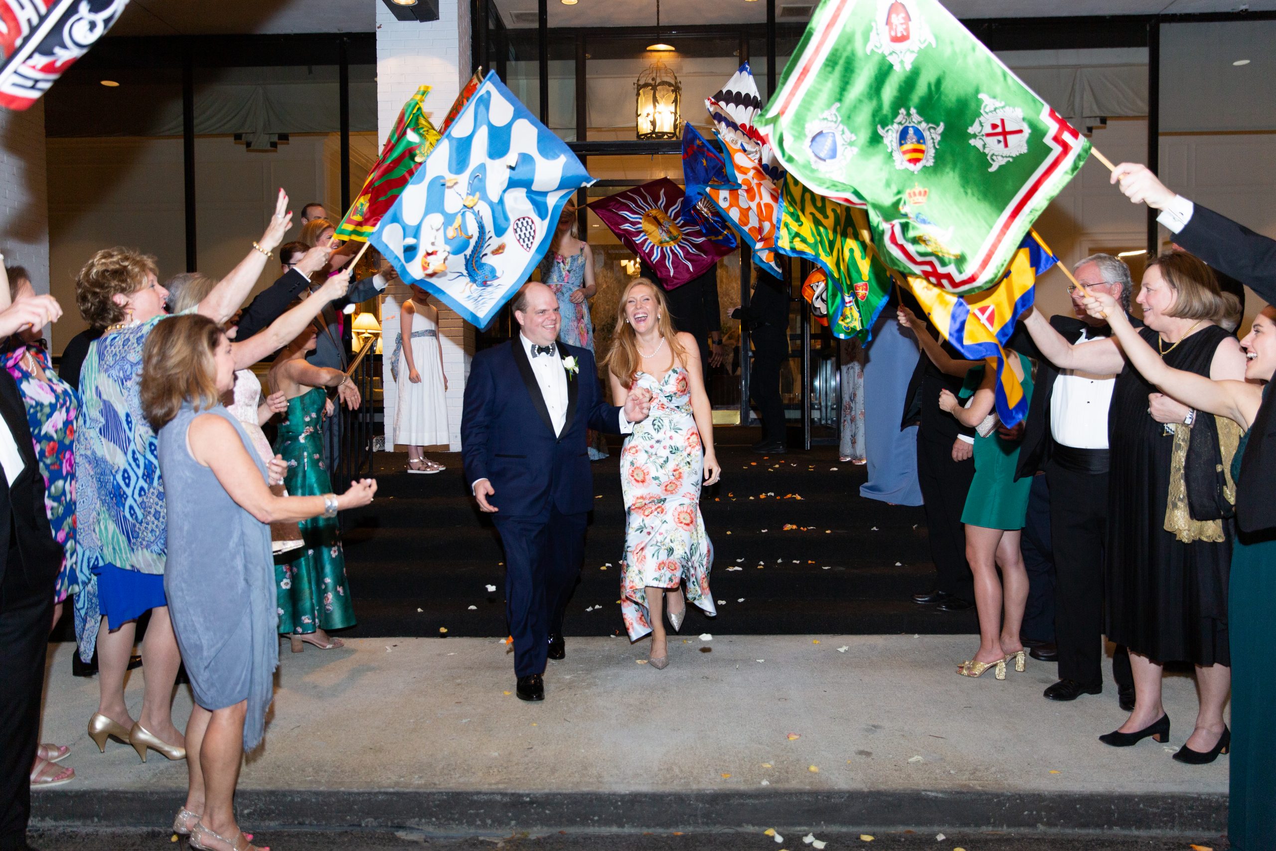 To see the bride and groom off, guests were handed Palio flags, a nod to the college semester Katherine spent in Siena, Italy. Unexpectedly, at that moment, Forest Lake’s sprinklers came on. Brilliantly, people hustled and put trash cans on top of the sprinklers so the couple wouldn’t get wet. 
