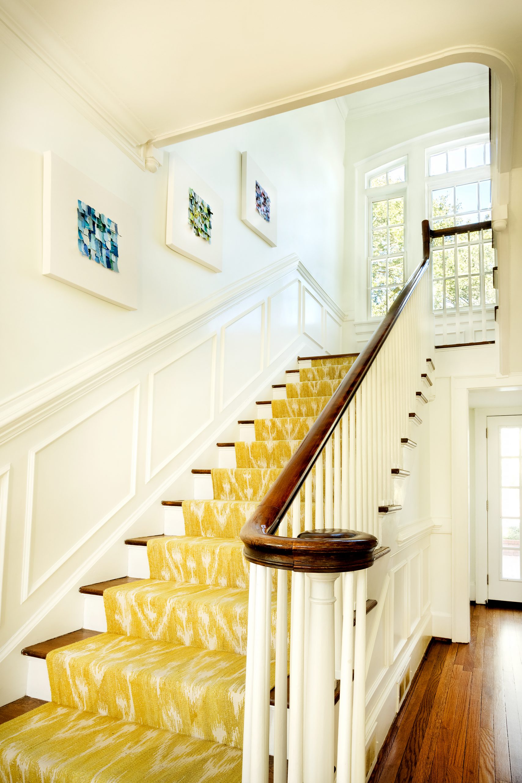 Art is everywhere in Karen’s home, and she not only has an eye for collecting it but also creating it. Along the staircase in their central hall, Karen has hung a series of canvases she created that are textured color studies made with strips of paper. 