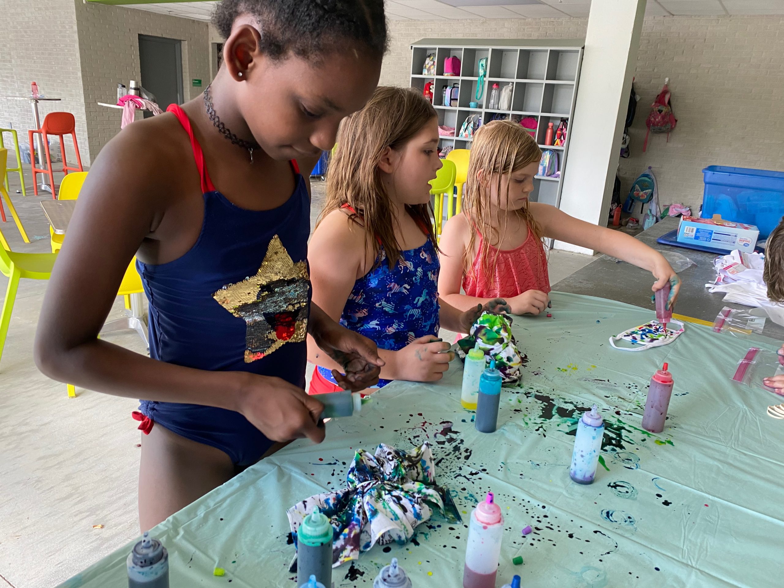During summer camp, for members and nonmembers, girls design their own tie-dyed shirts on the outdoor patio.