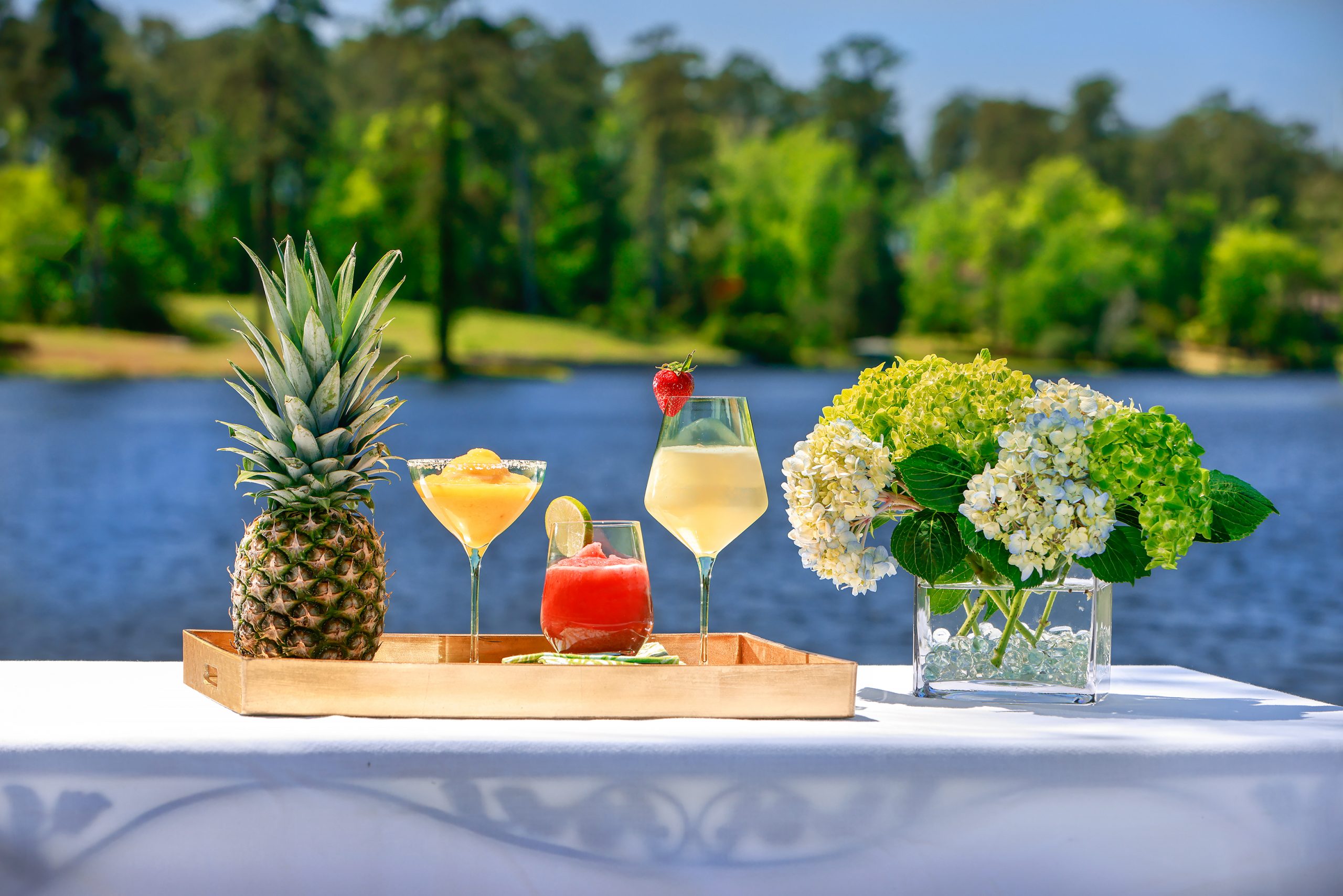 Surrender from the heat, lakeside, to a Martinez Mango Marguerita, Papa’s Deliciously Decadent Frozen Daiquiri, or the Poplawski Piña Colada. A variety of Estelle glasses and Creative Co-op napkins, courtesy of Kudzu Bakery & Market.

