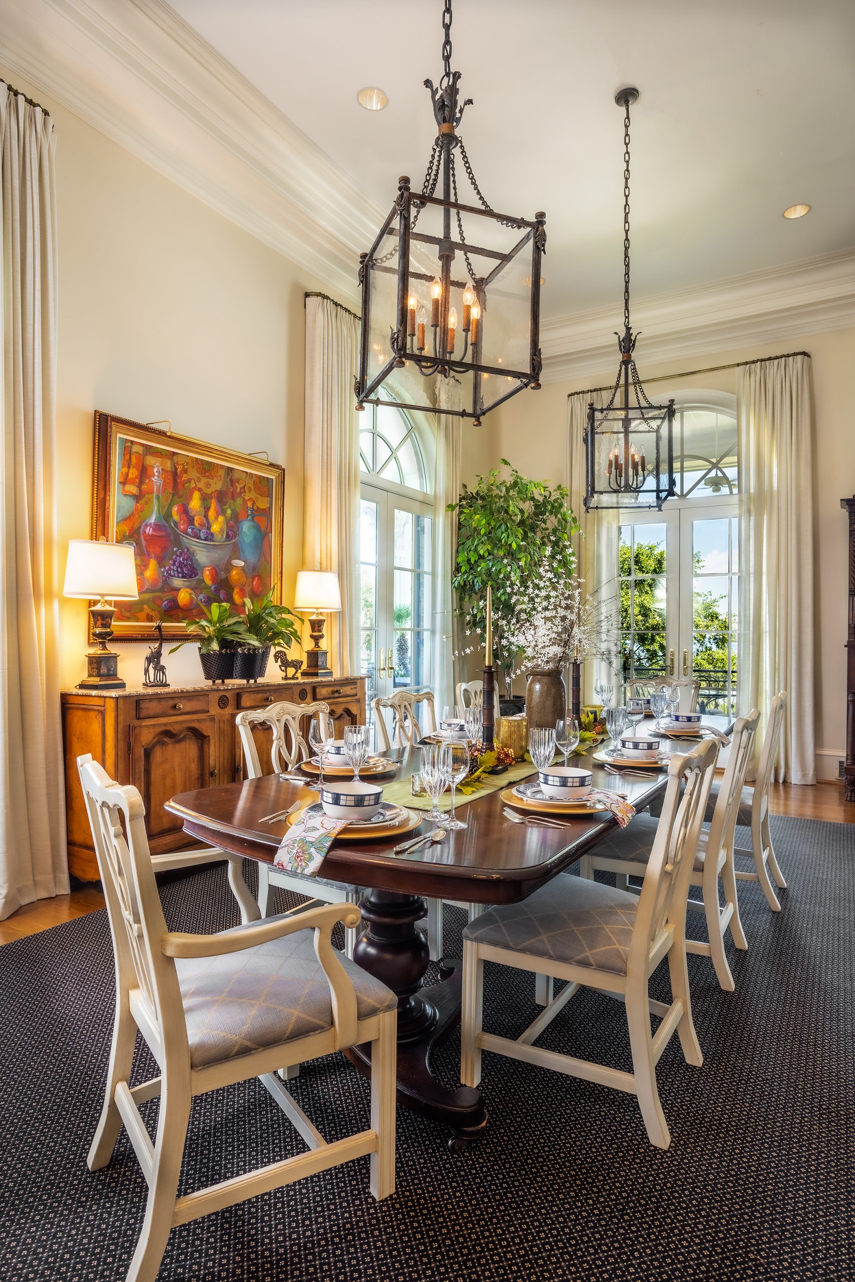 Natural light floods the breakfast room, adjacent to the family room and kitchen. Multiple Palladian French doors crest just below the 14-foot ceilings. Circulation from the wraparound porches, with stunning lake views, is accessible with the turn of a doorknob.