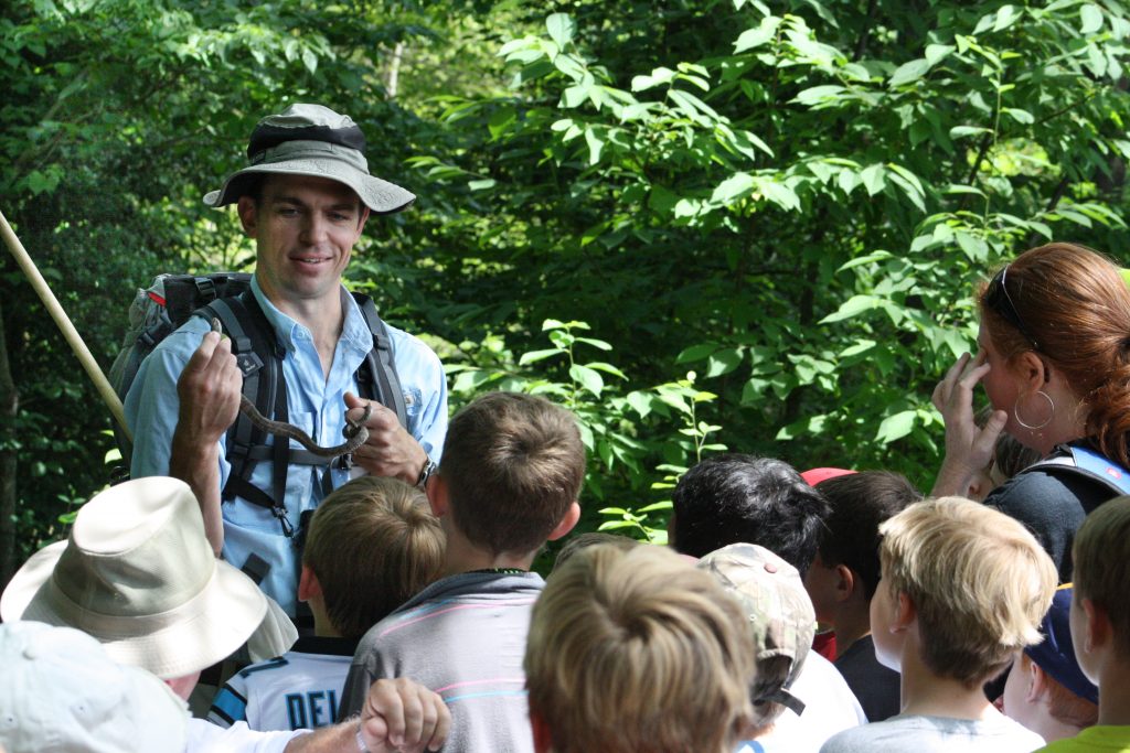 Austin Jenkins, SCWF’s Midlands master naturalist instructor, educates a group of kids about a snake while on a walk at Landsford Canal State Park. 
Photography courtesy of SCWF