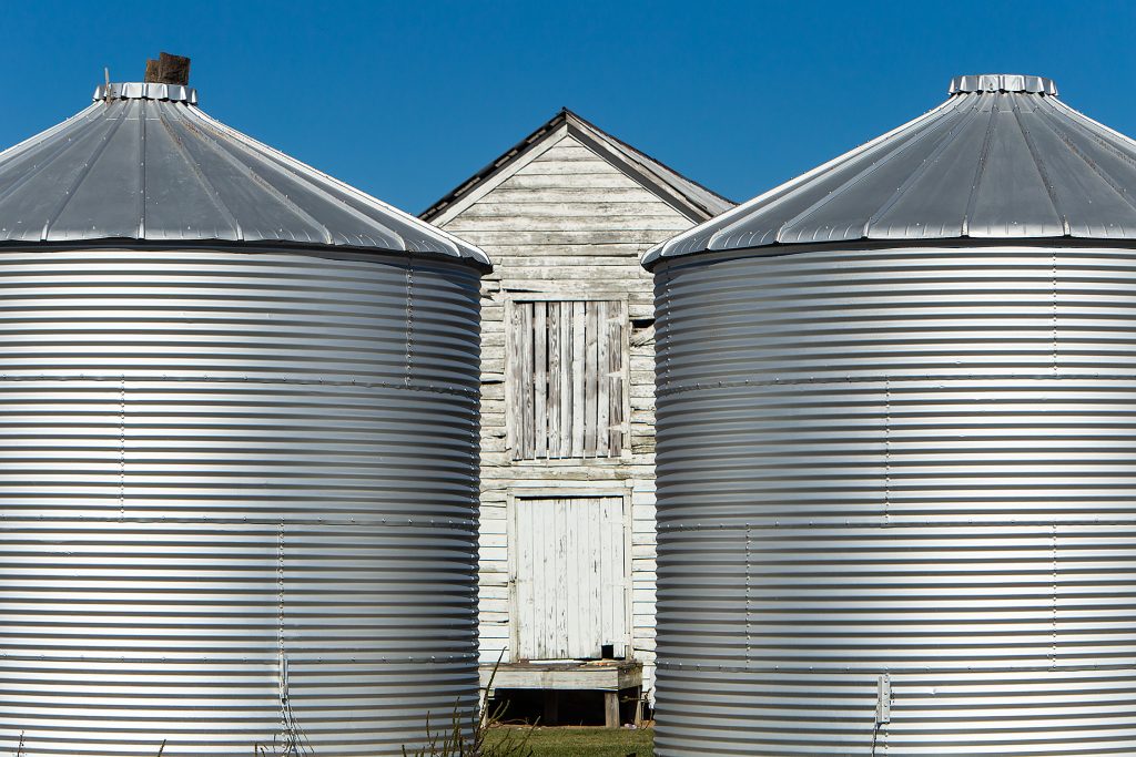Here Today, Used Tomorrow — Proper farming practices like crop rotation ensure farmland does not become monotonous in character. Grain bins aid in storing soybeans, corn, or animal feed for next year’s crop other than cotton.
