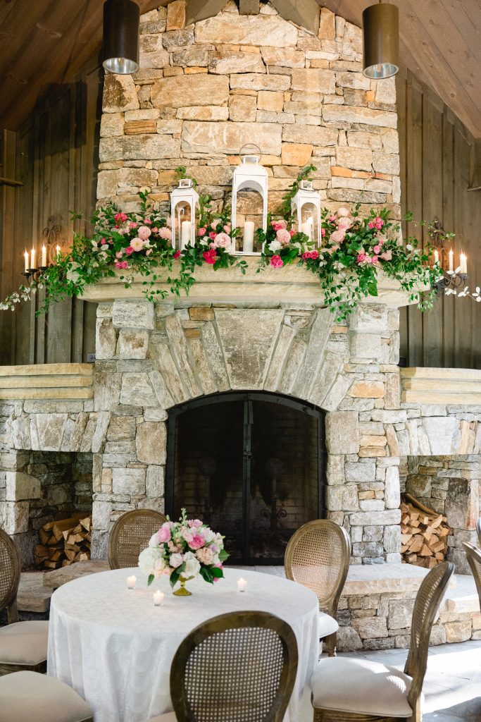 Entering the reception to the sound of an instrumental trio, guests found themselves surrounded by Julianne Sojourner’s elegant arrangements of pink and white roses, sweet peas, hydrangeas, and tulips, which dotted tables and filled the mantel of the stacked-stone fireplace. 