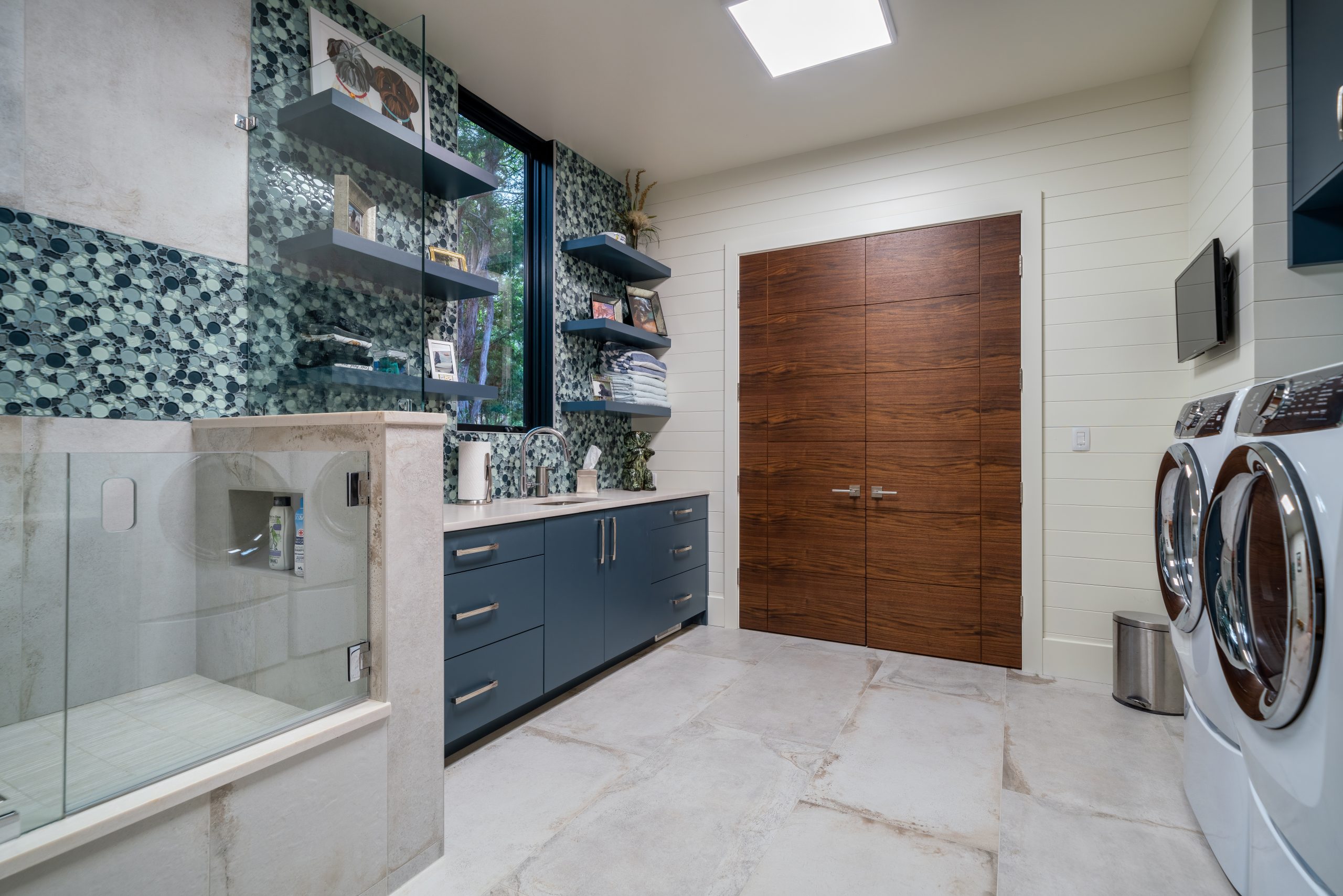 A large combination laundry room and dog showering area is located down a hallway beside the kitchen. 