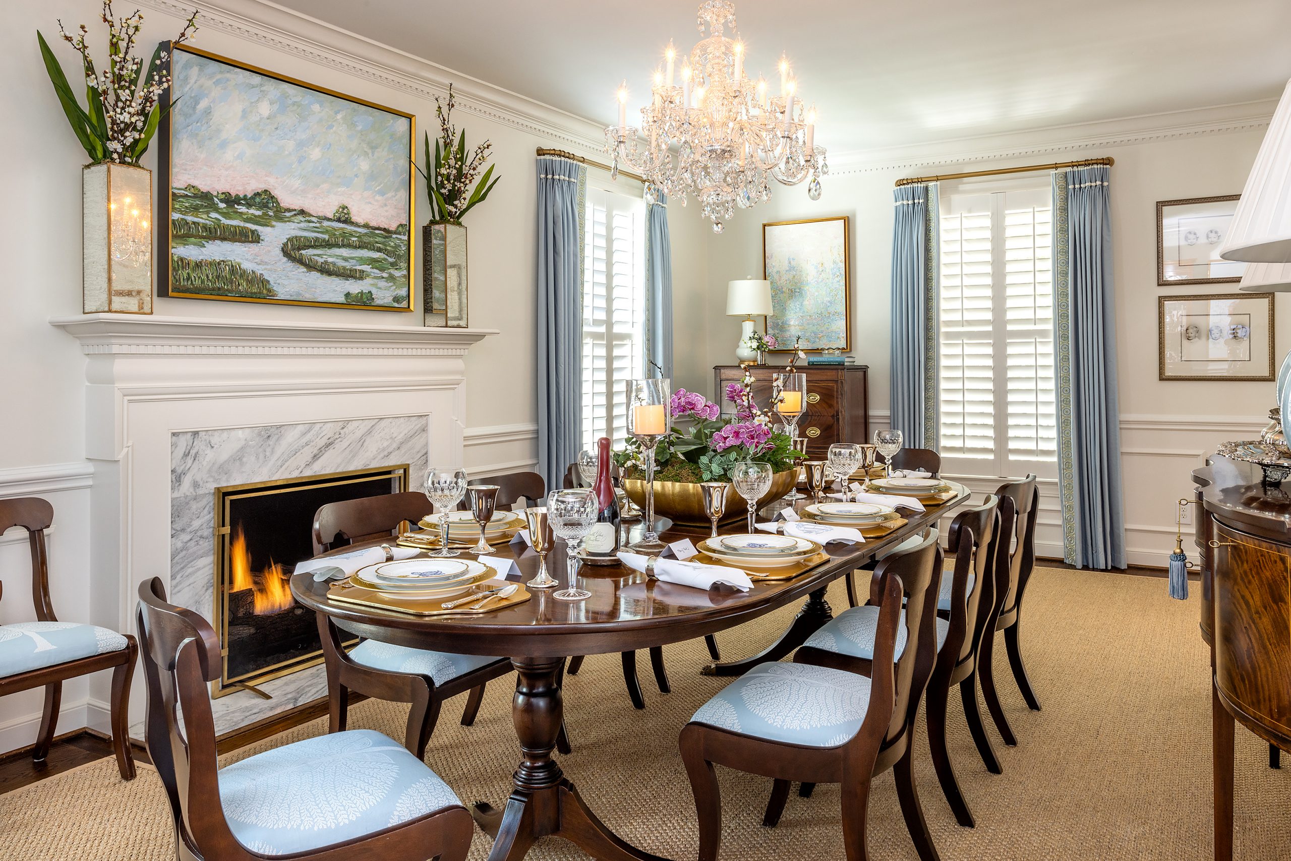 When the Andersons purchased their home in 2019, the original dining room was a small space, so their designer, Elizabeth Newman of Charleston, had the idea to flip the original living room with the dining room. To make the new dining room more elegant, they added wainscoting and heavy molding, along with a large hand-cut crystal chandelier. Mary Kirk inherited her grandmother’s large oval mahogany inlaid Virginia Galleries dining room table, sideboard, and dining chairs. The room holds them graciously.