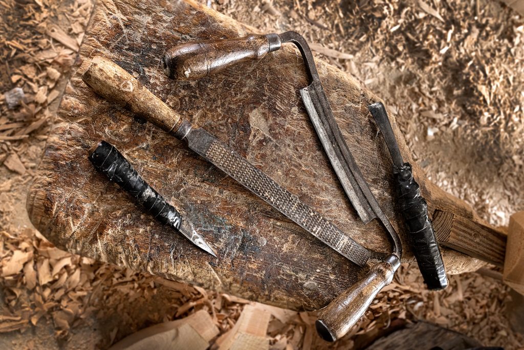 From left to right, the four tools Tom uses to create his art: a buck knife, rasp, draw blade, and wood chisel. Tom wraps various tools with electrician tape to cushion his hands against the constant pressure while shaping decoys out of wood. 
