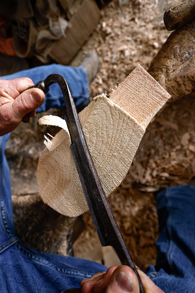  Without outlining or measuring, Tom uses experience to shape a rough body of wood using a draw knife. After passing the tool over the wood, Tom uses his hands to feel the wood and determine the next action to craft a perfectly balanced decoy, capable of floating on water during the hunt.